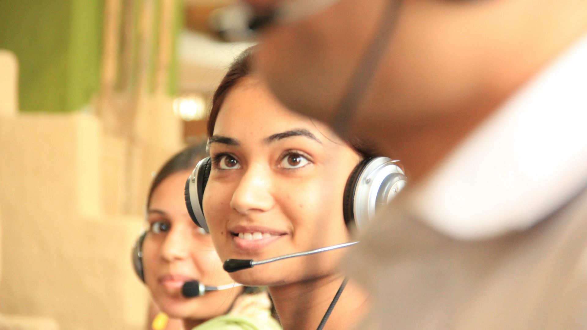 woman in black headphones holding black and silver headphones