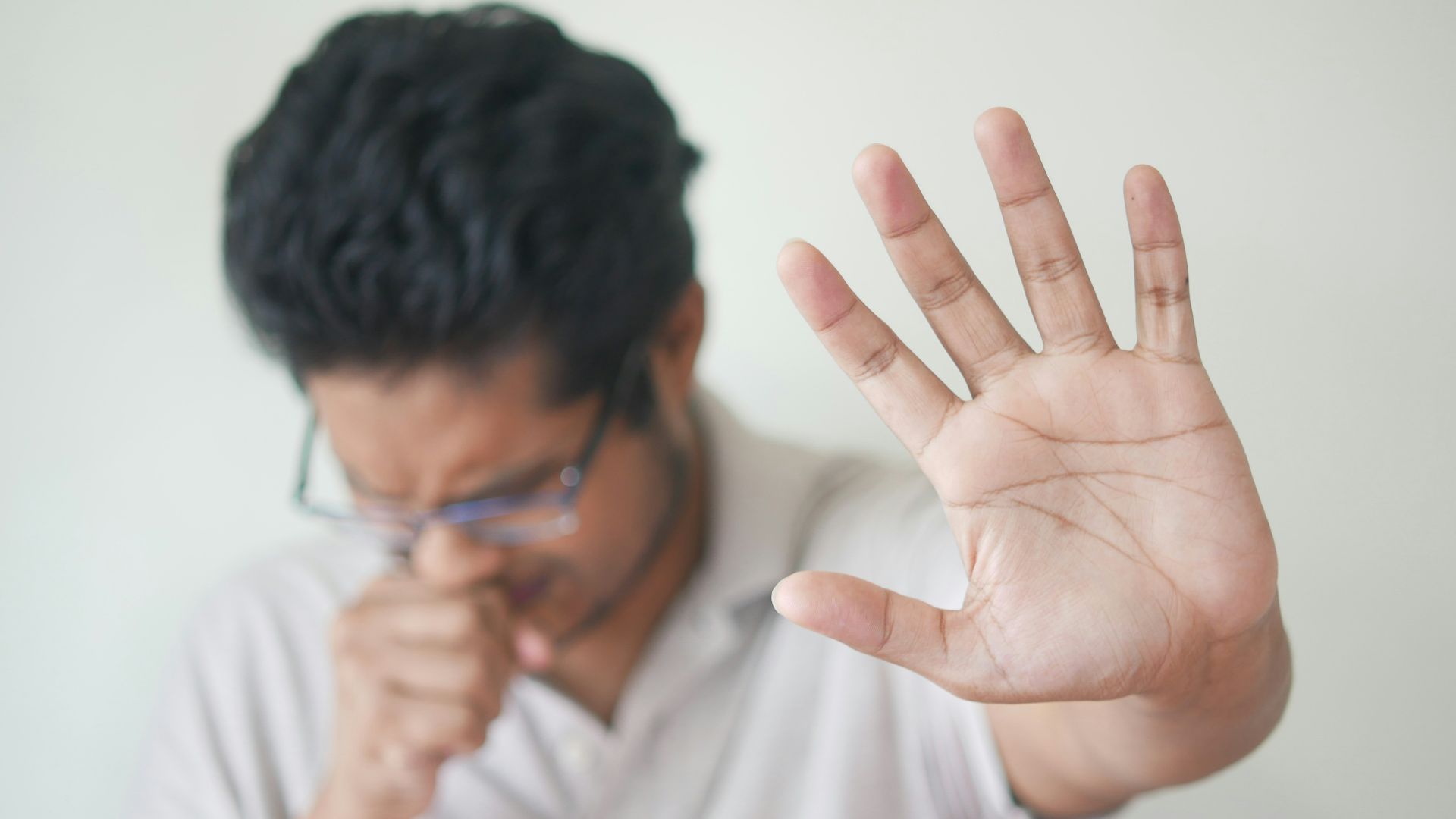 a man holding his hand up in front of his face