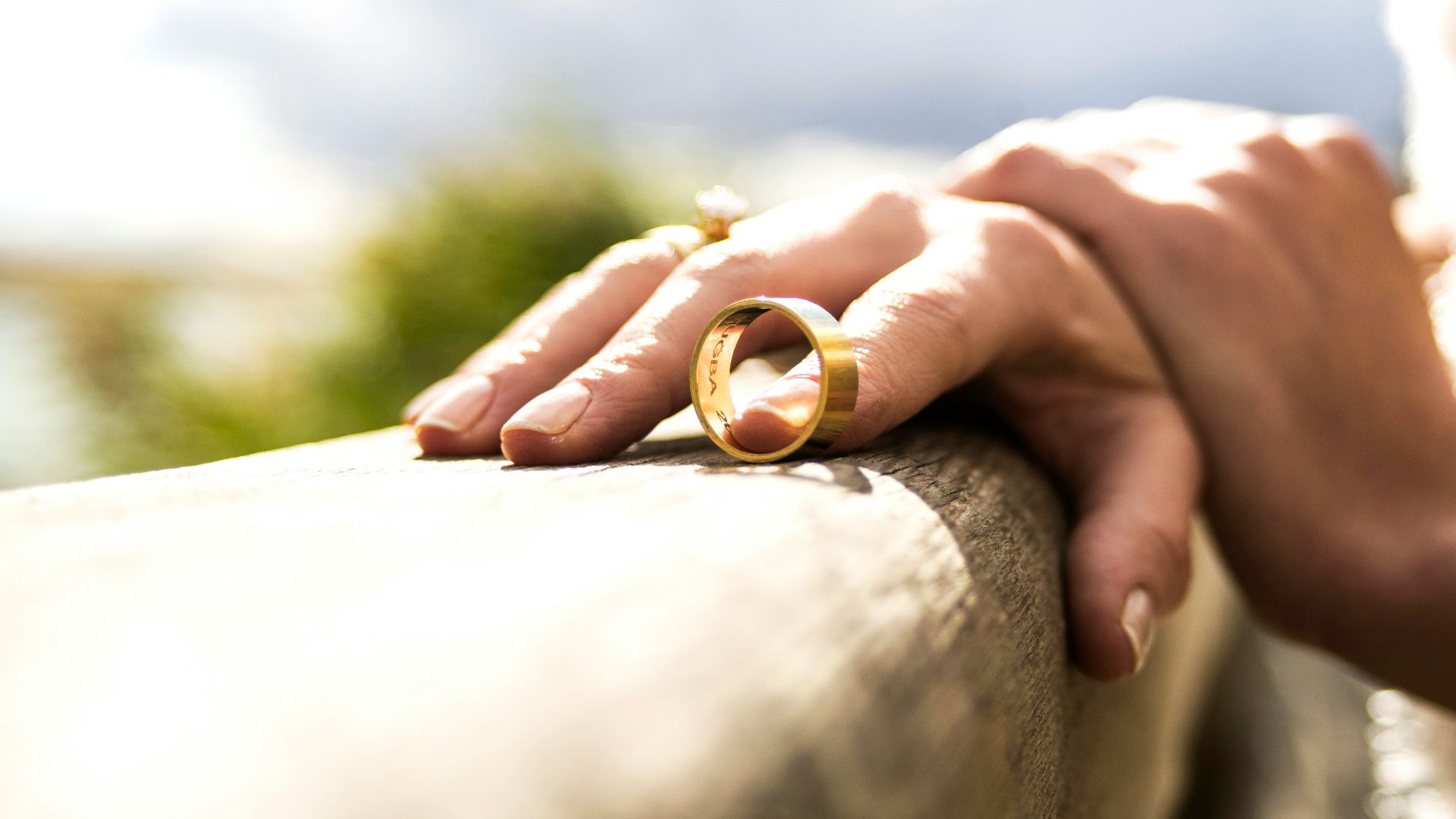 person holding gold wedding band