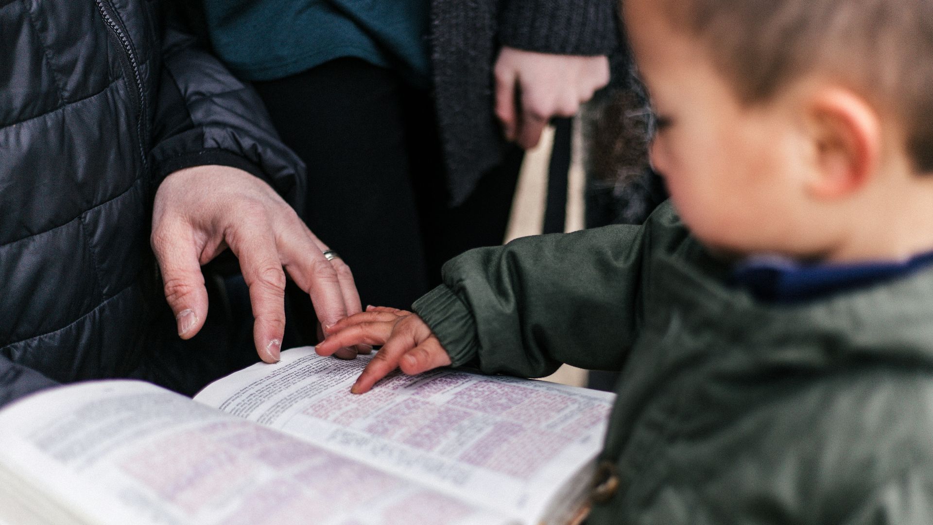boy touching page of book