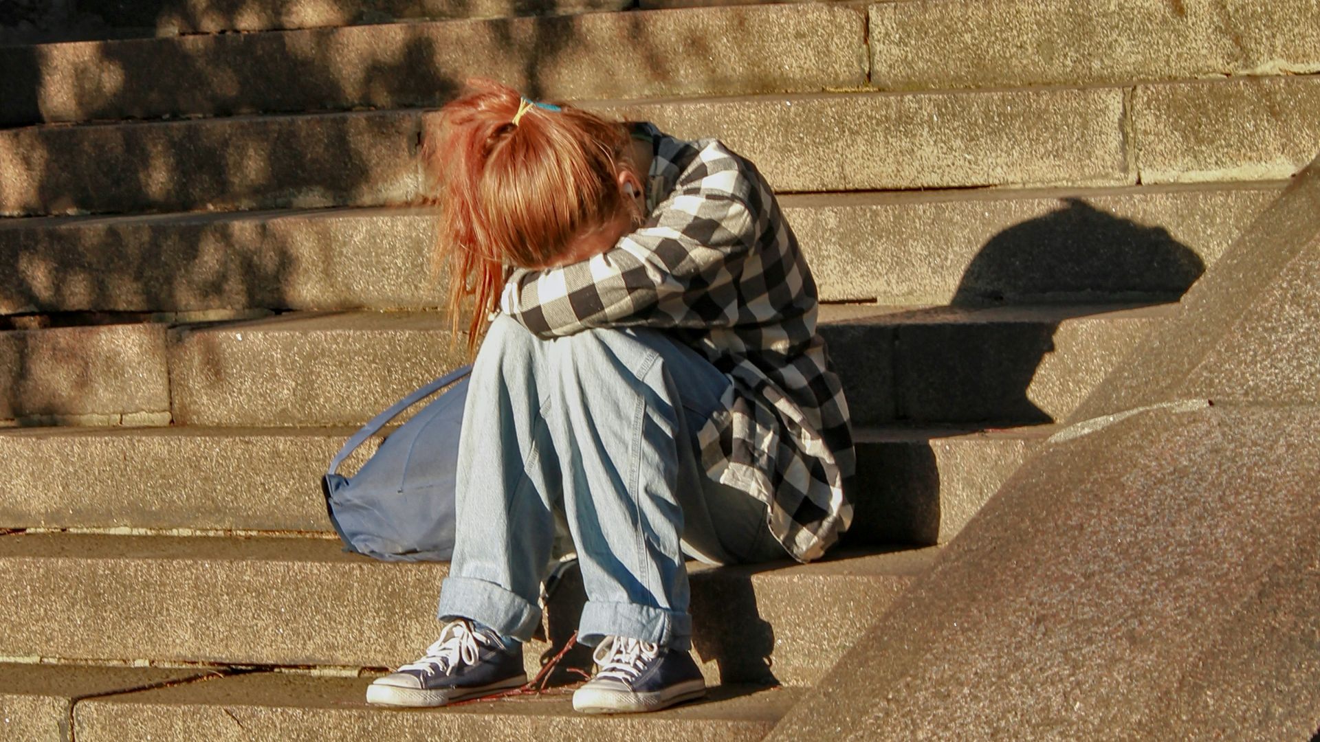 woman in black and white dress sitting on concrete stairs