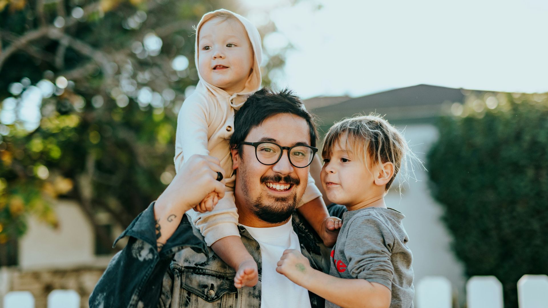 man in white shirt carrying girl in gray shirt