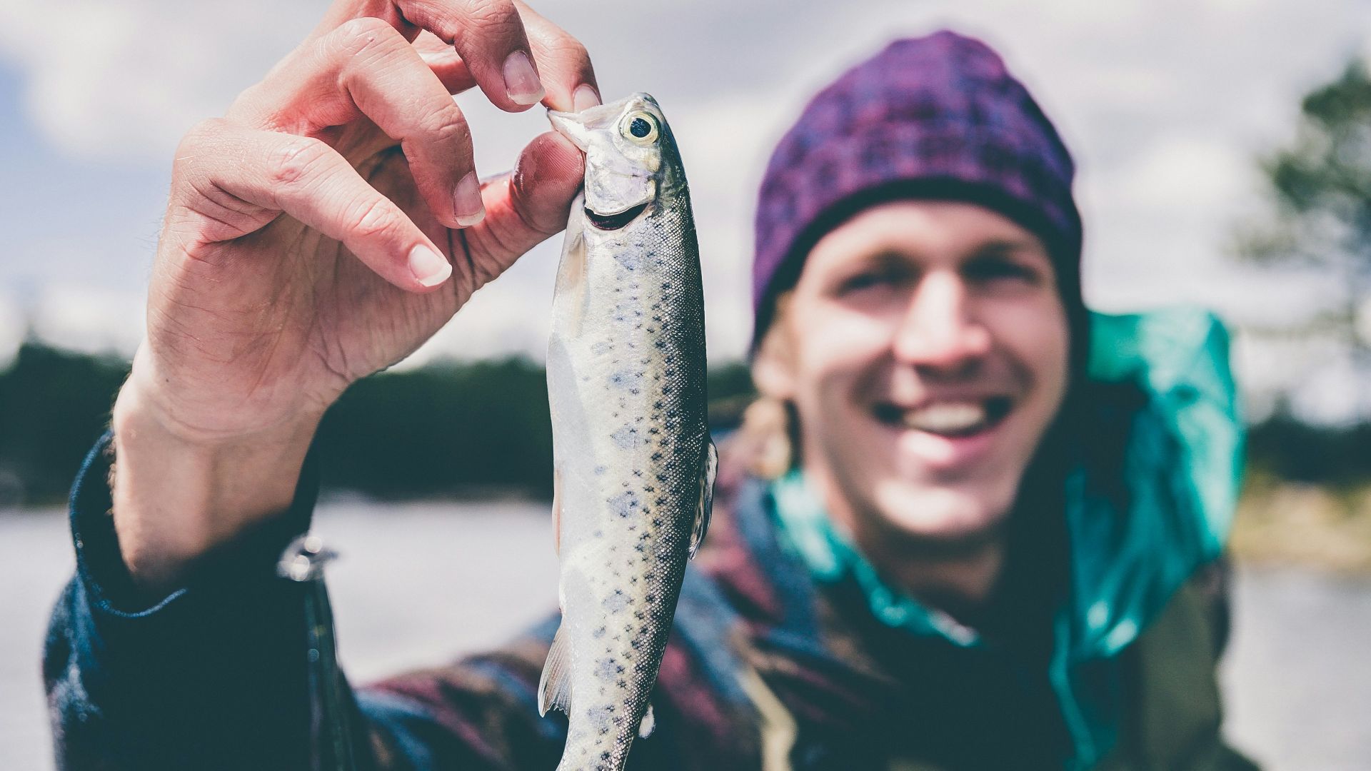 depth photography of man holding fish