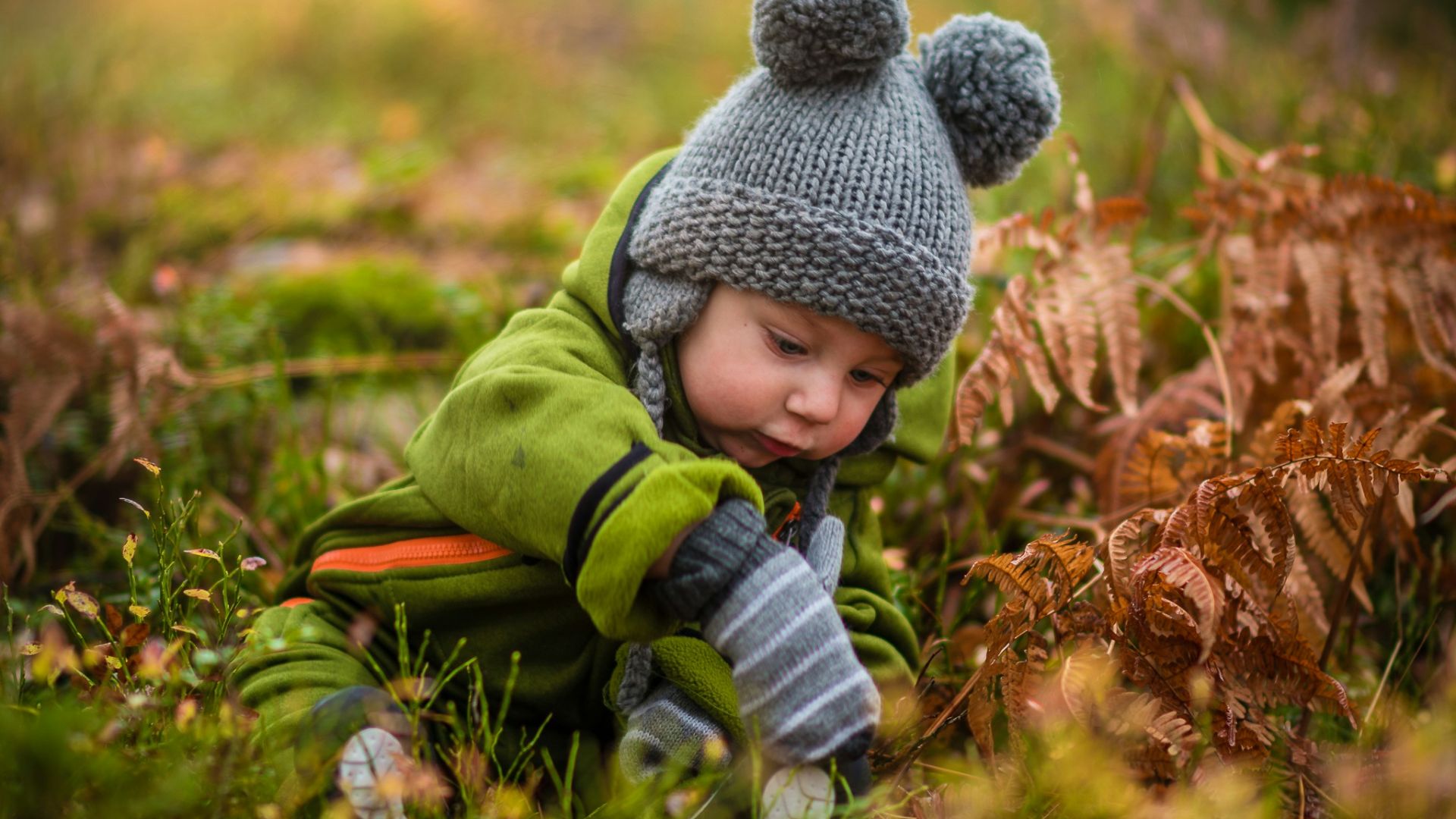selective focus photo of baby on green grass field