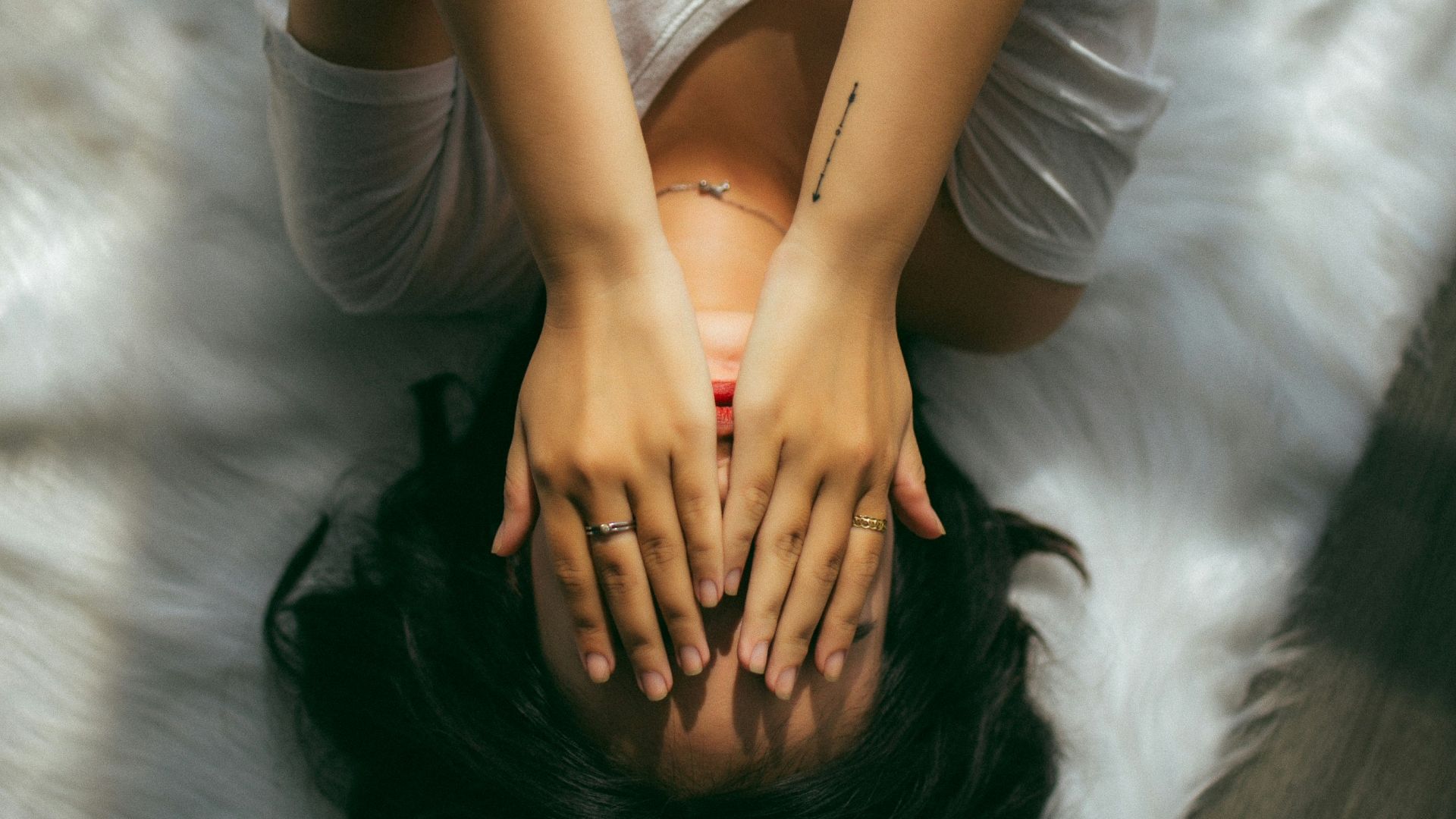 a woman holds her hands over her face