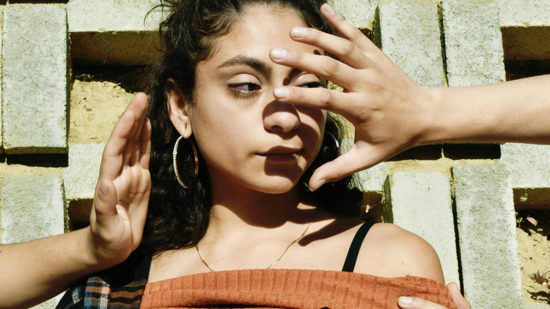 woman in black and white plaid dress shirt holding blue leather pouch