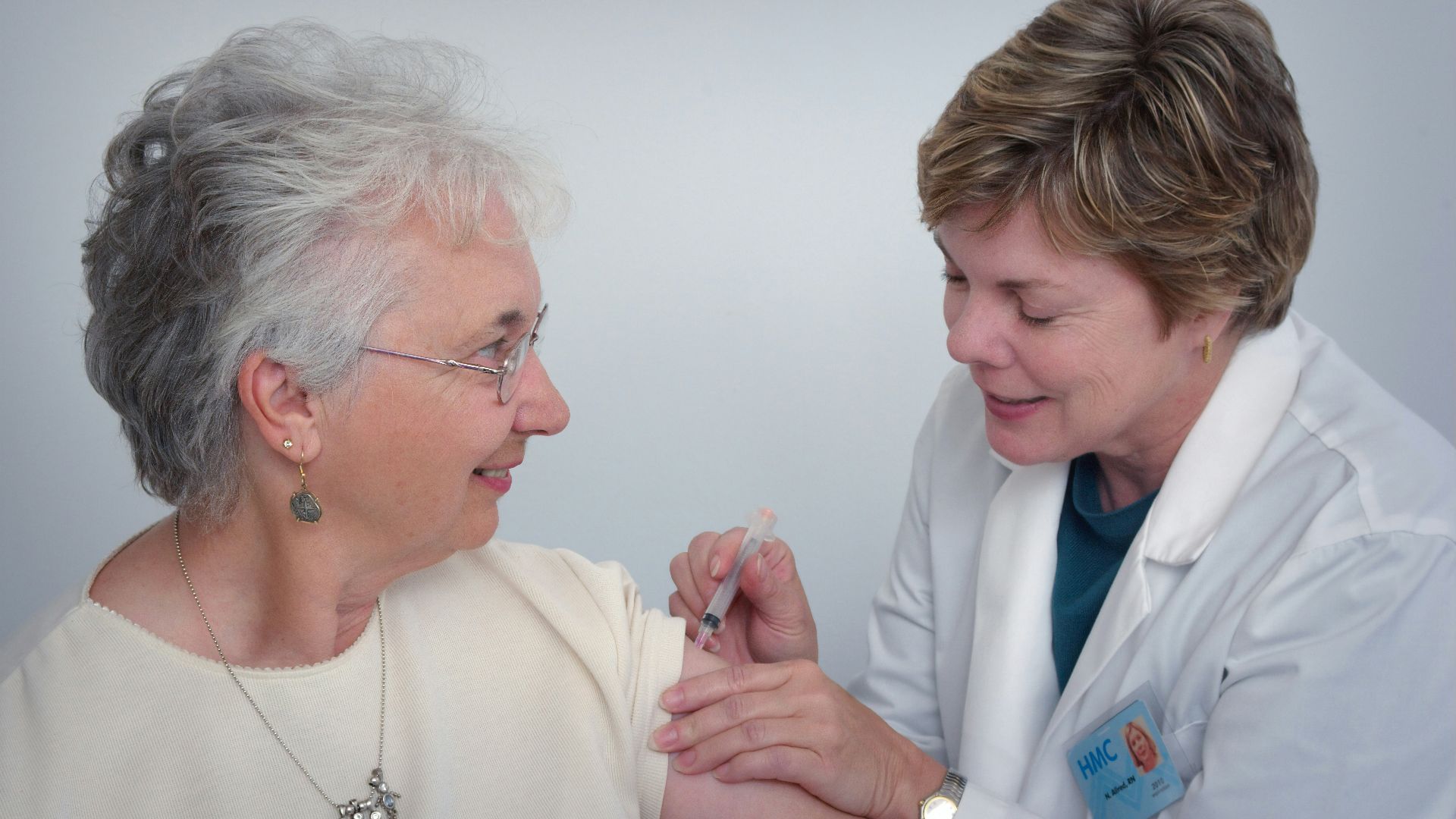 woman inject a woman on left shoulder