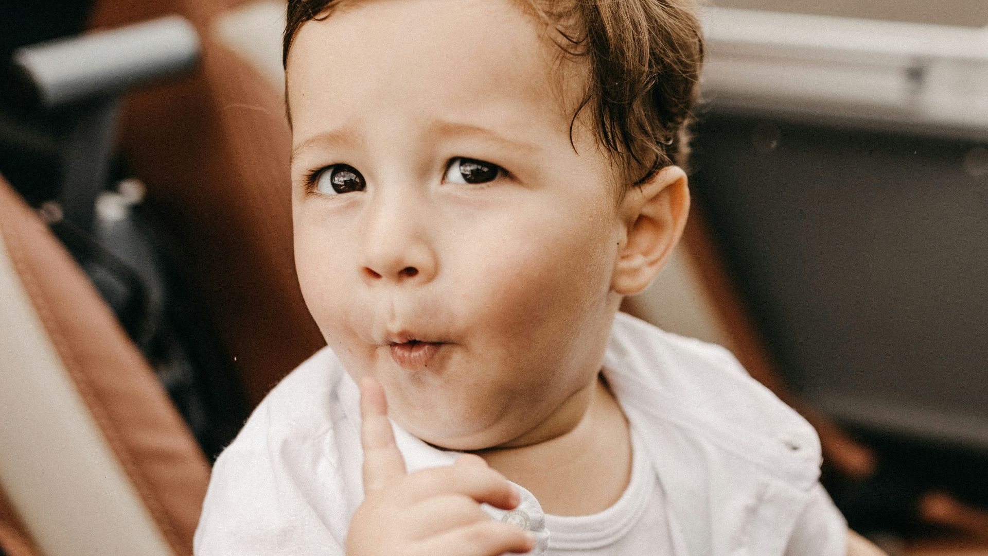 boy wearing white button-up t-shirt, white tank top and brown bottoms