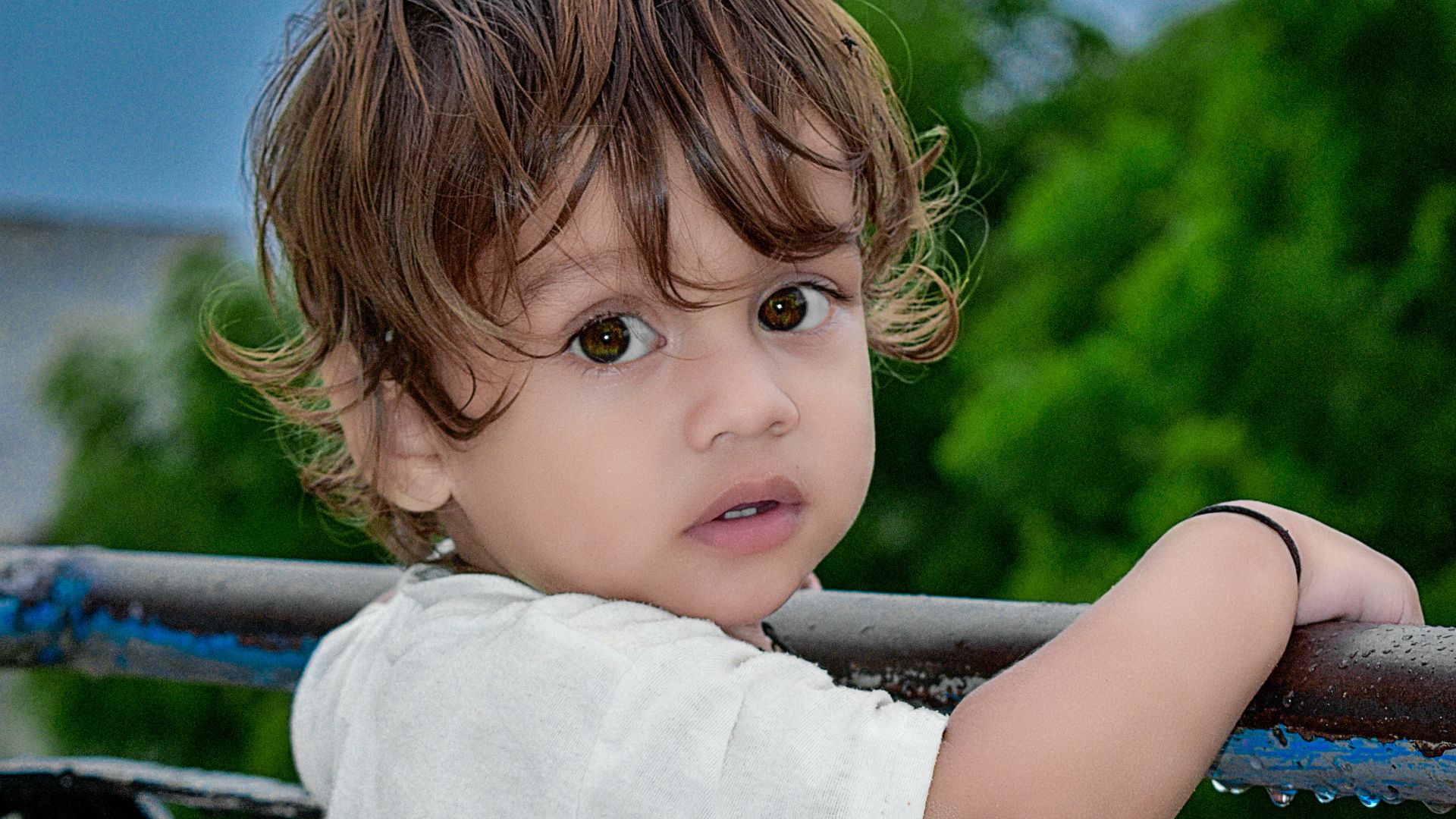girl in white shirt standing on black metal railings during daytime