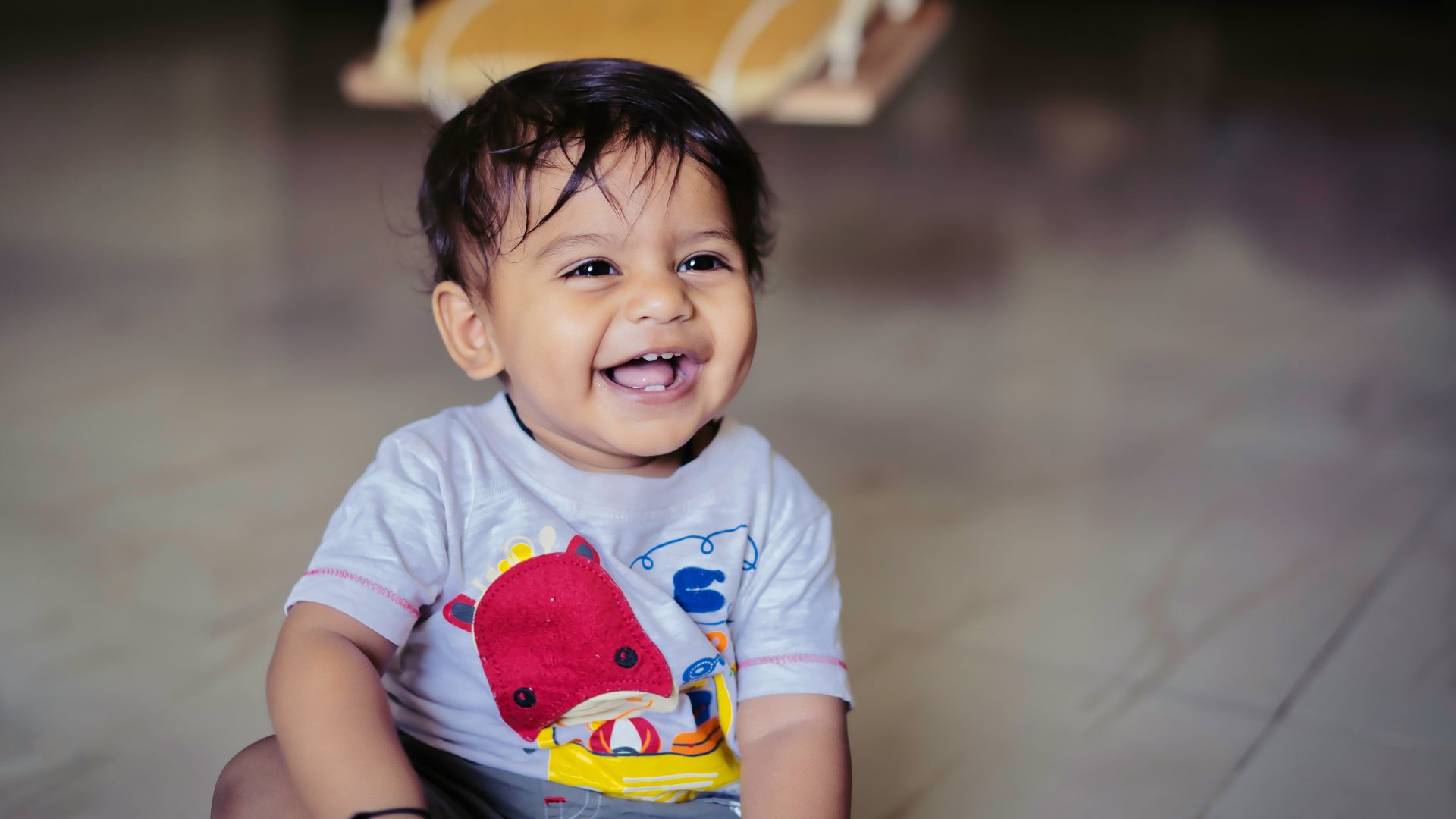 boy in blue and red crew neck t-shirt sitting on yellow and white chair