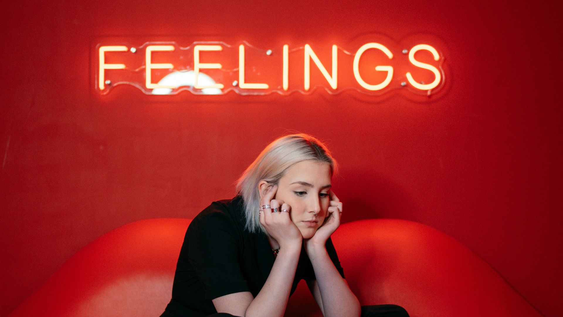 woman in black long sleeve shirt and black pants sitting on red couch