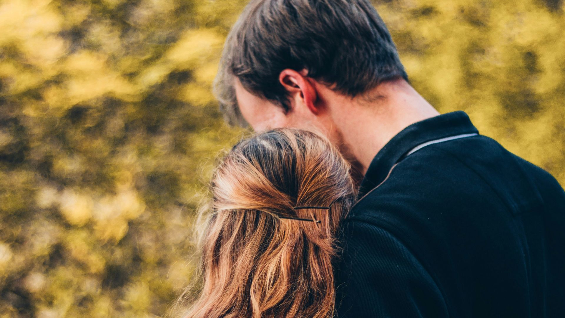 woman and man standing beside tree at daytime