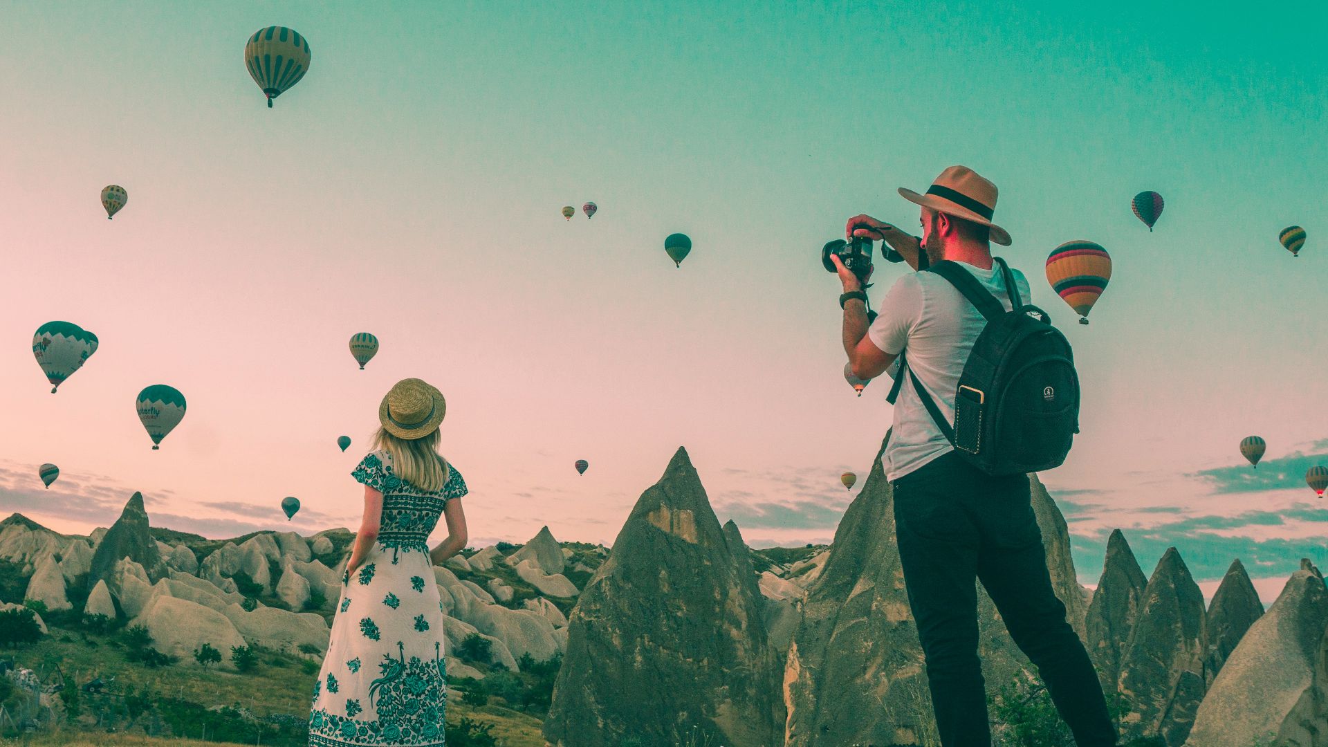man taking photo of hot air balloons