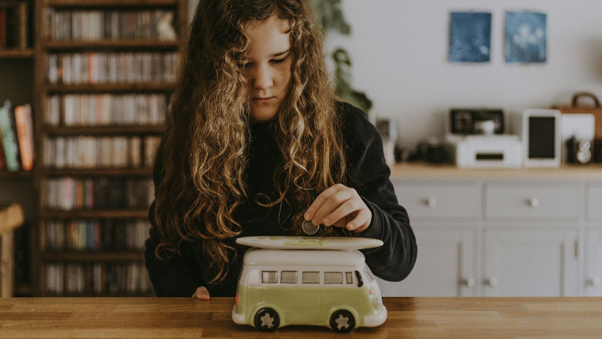 girl wearing black sweatshirt playing toy car