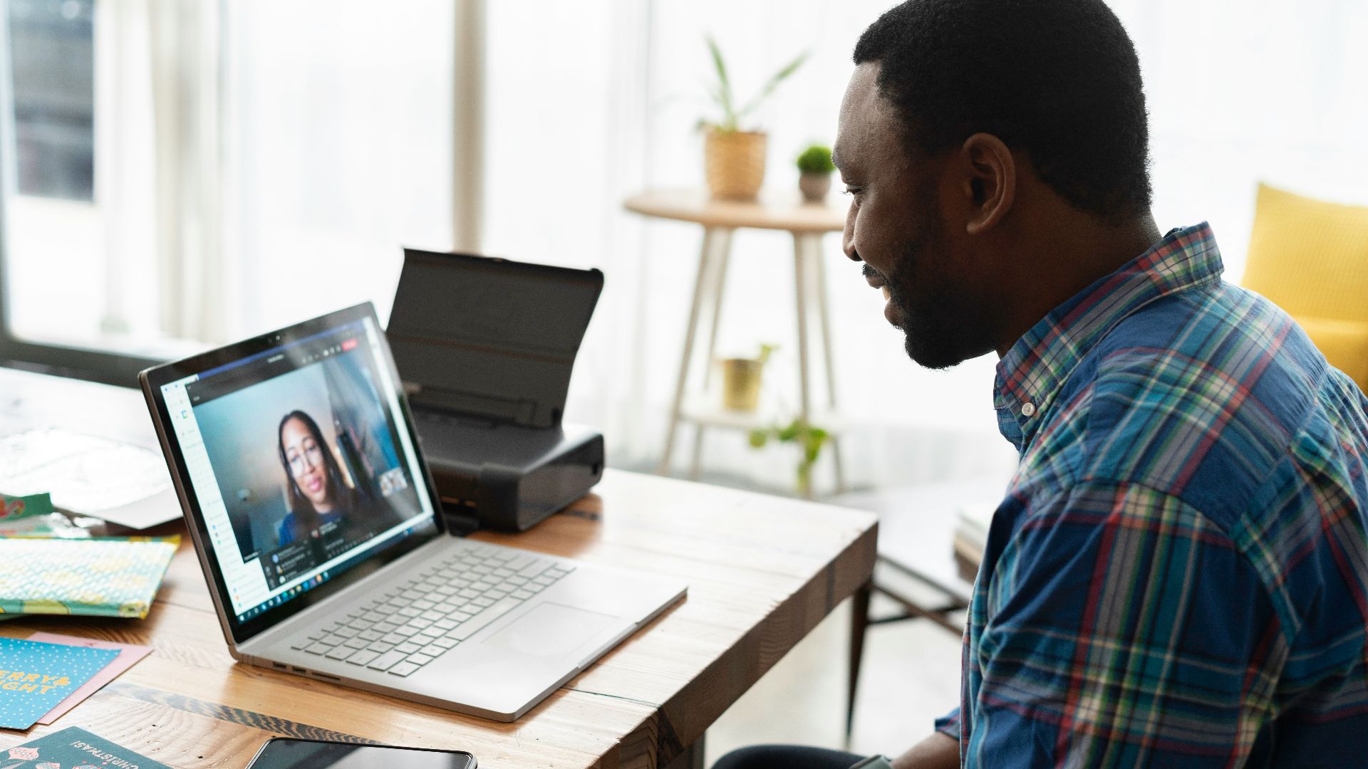 man in blue and white plaid dress shirt using macbook pro