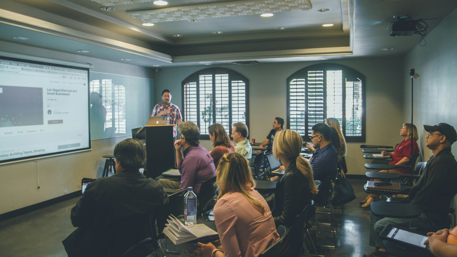 a group of people in a room with a projector screen