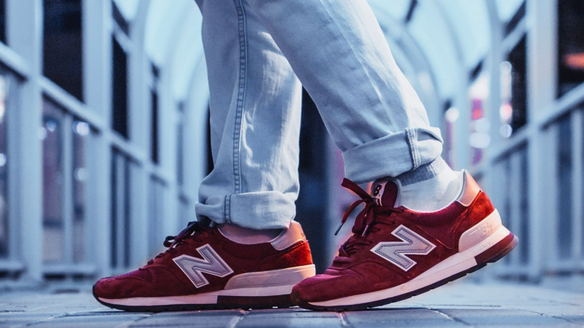 person wearing pair of red New Balance low-top sneakers