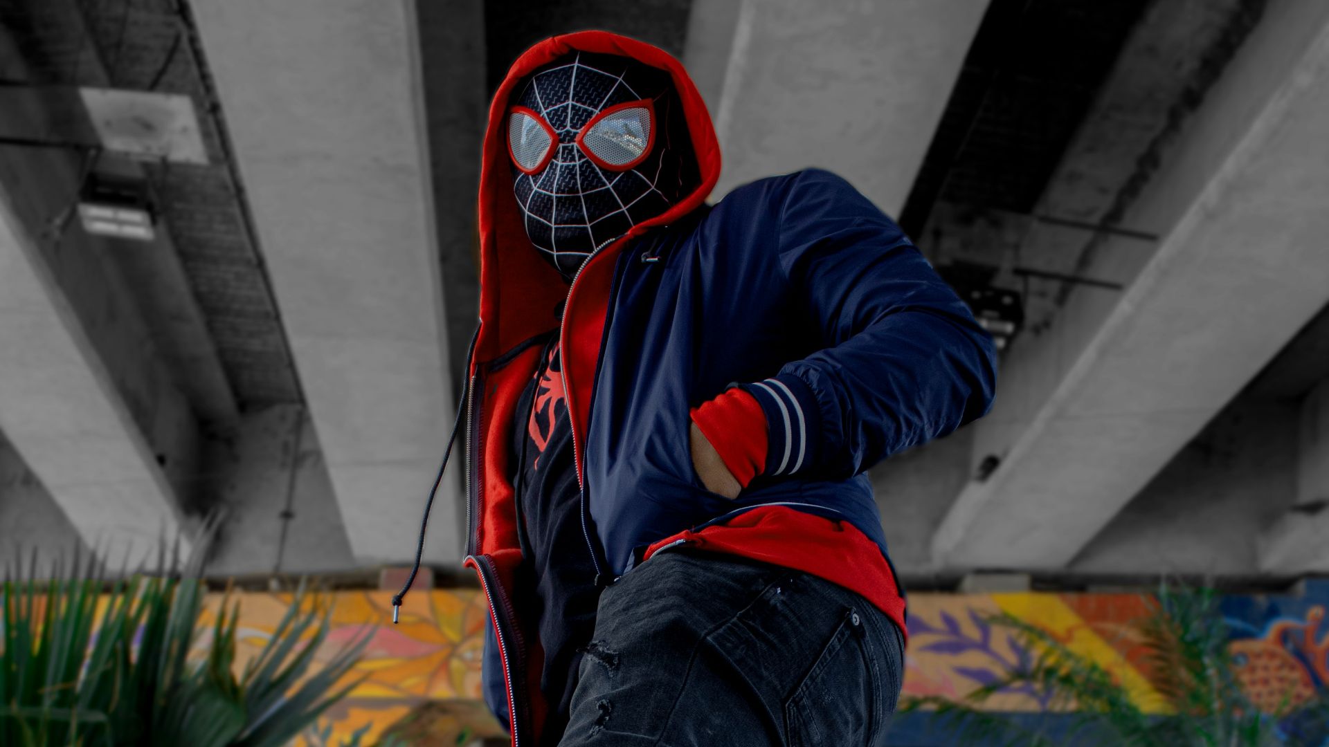 a man in a spider man mask is doing a trick on a skateboard