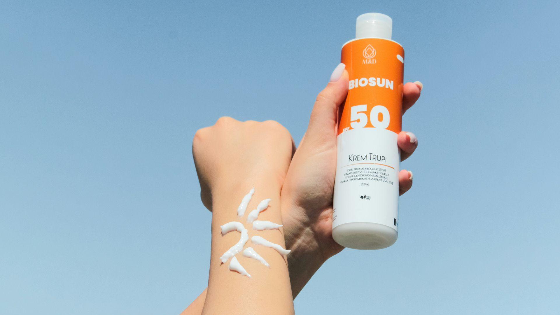 a person holding a bottle of sunscreen in their hand