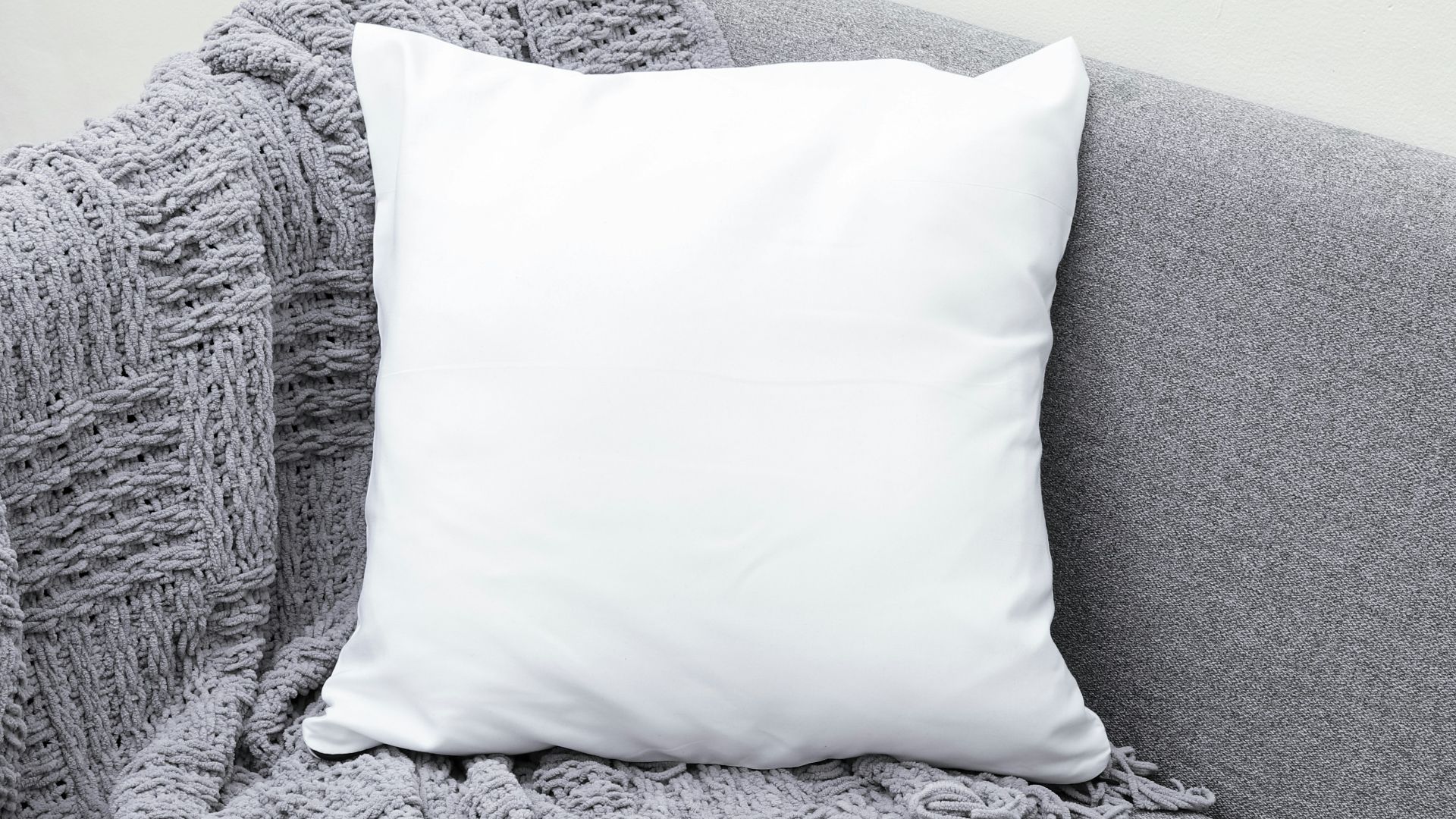 white throw pillow on gray sofa