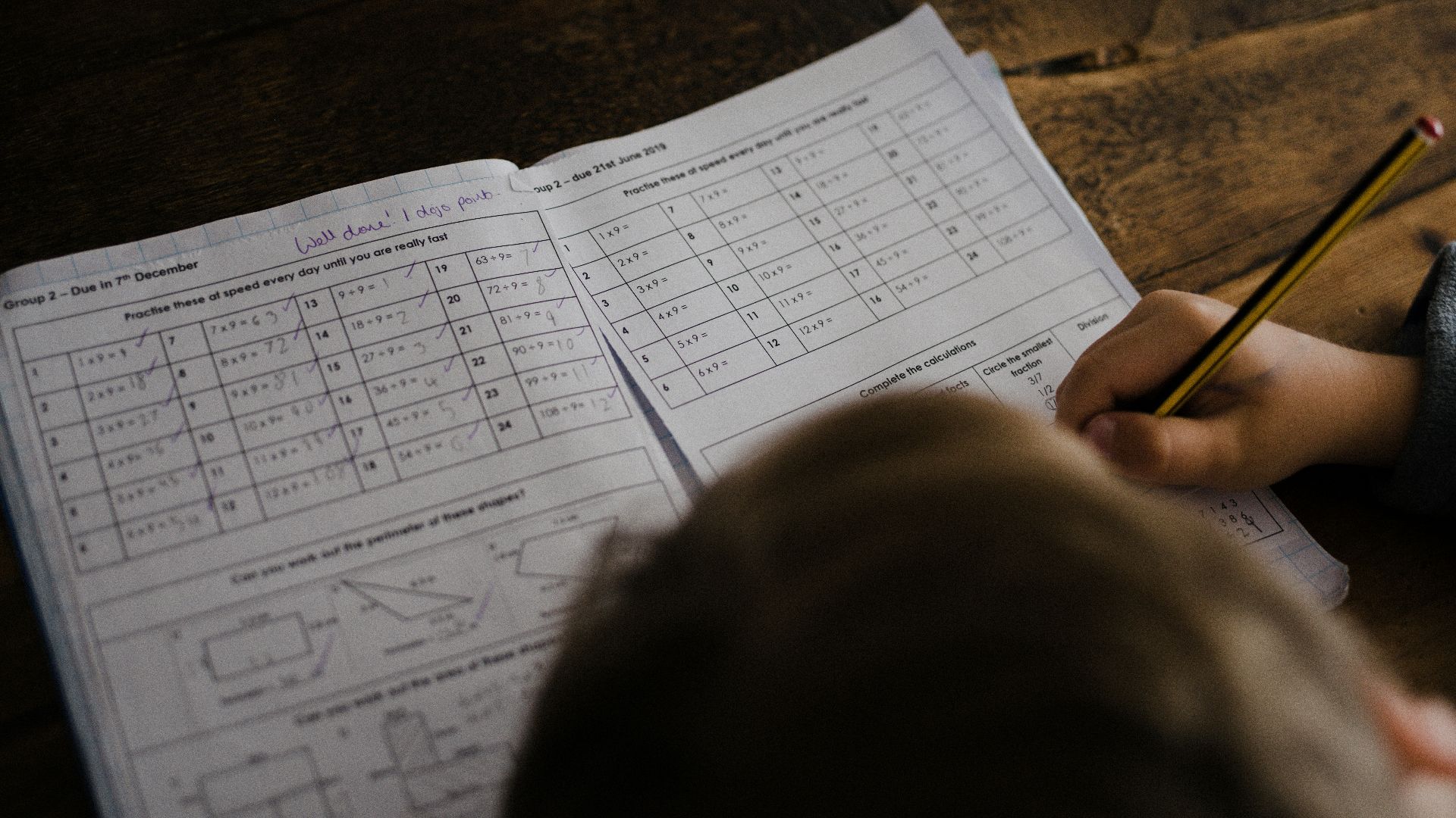 boy writes on his book on the desk