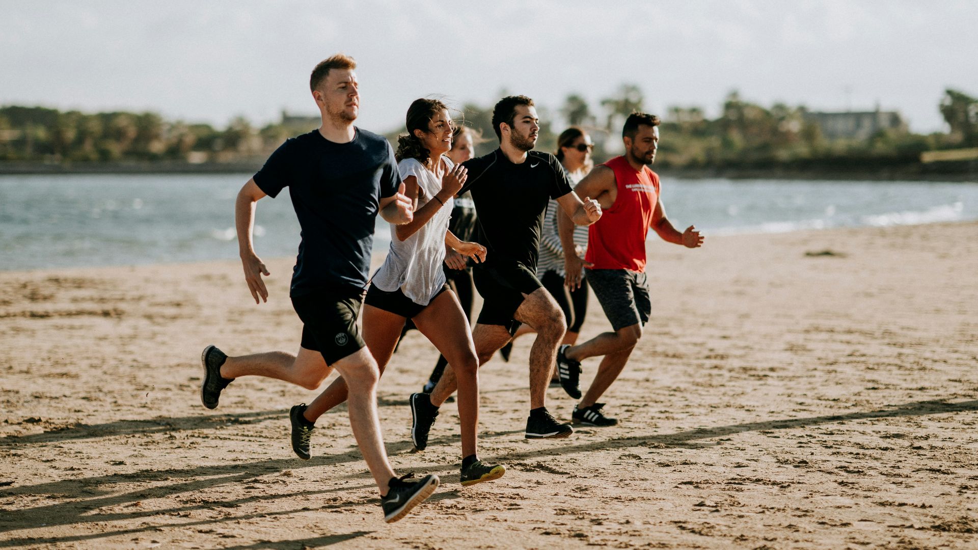 men and women running on sea shore