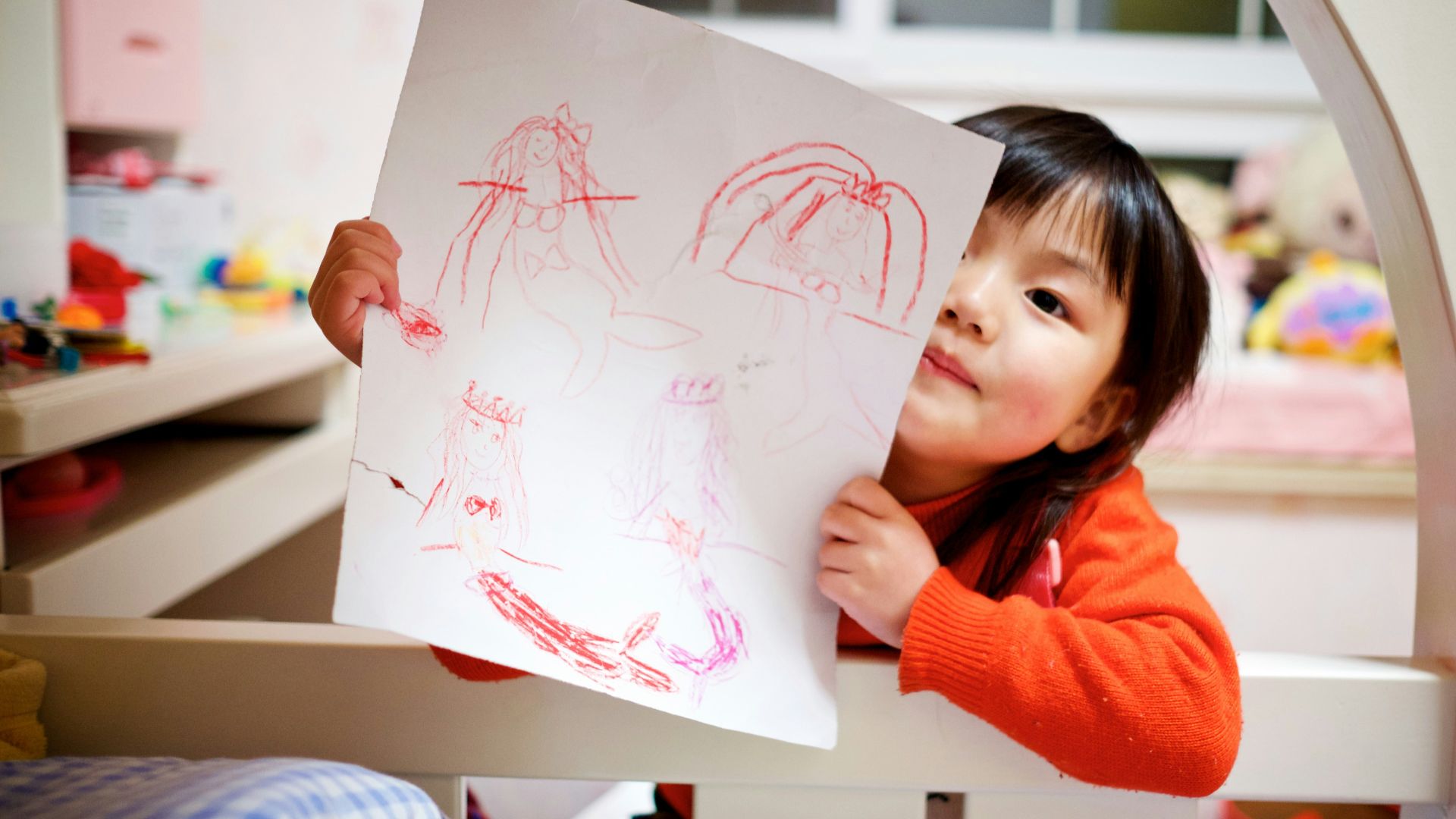 girl holding paper with drawing