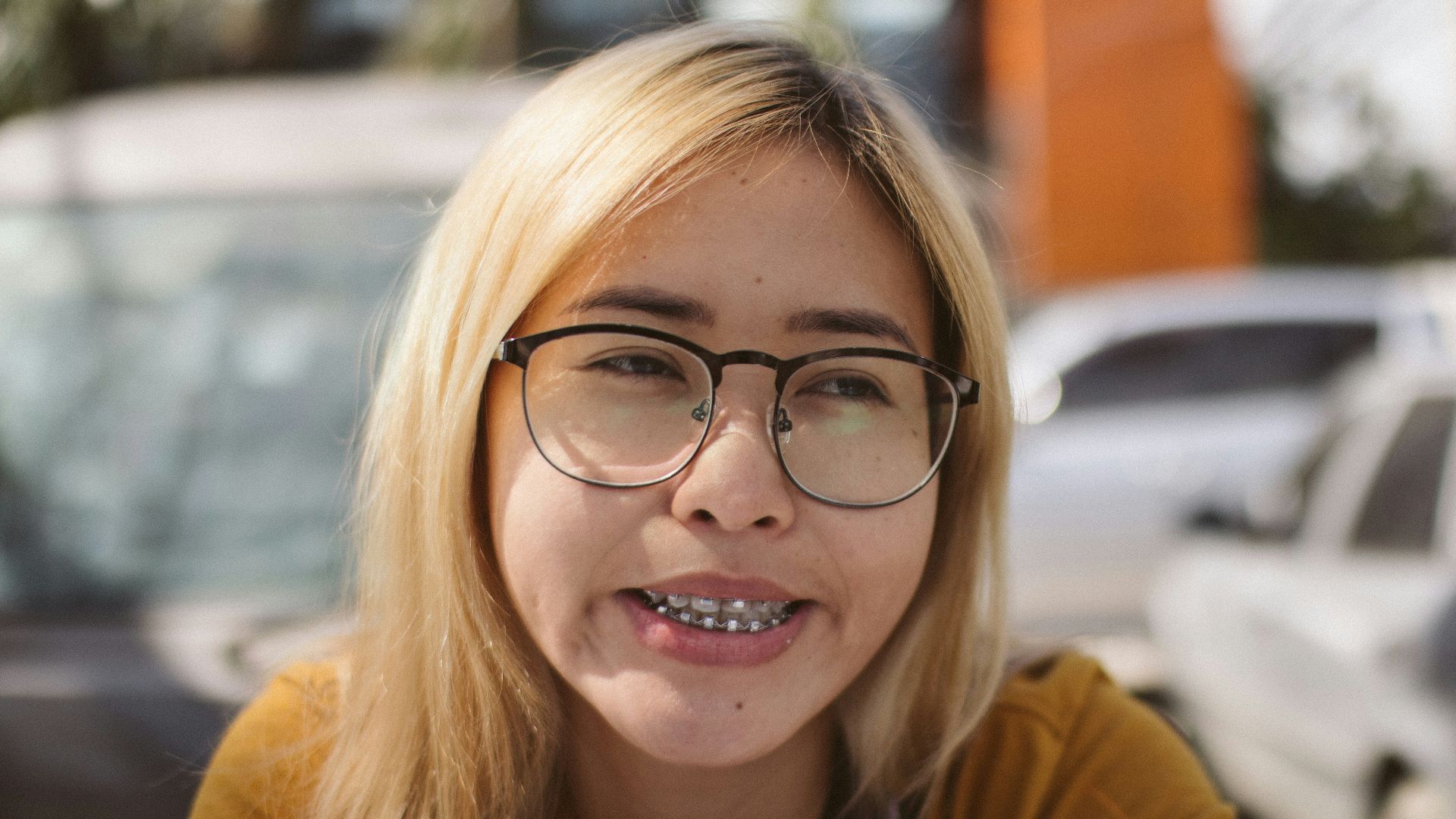 a woman with glasses and a smile on her face