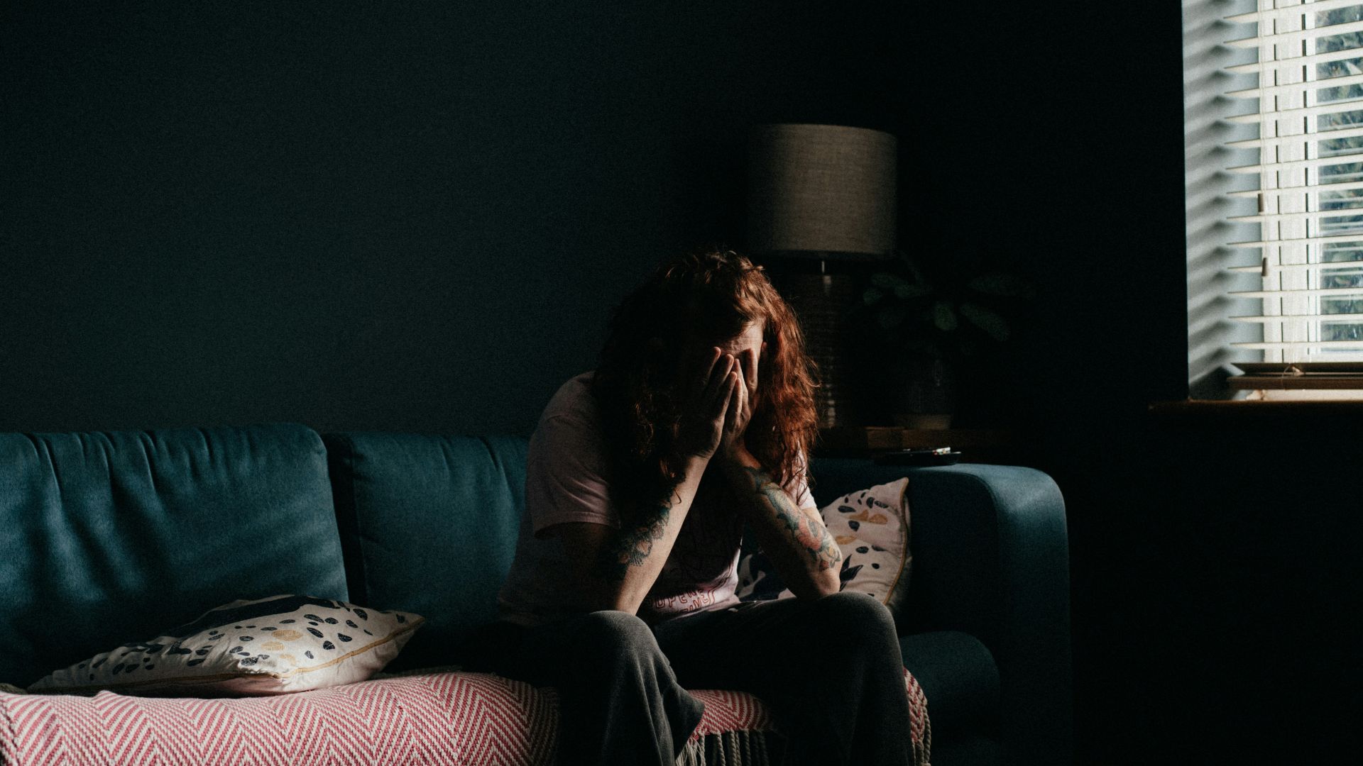 woman in black tank top sitting on black couch