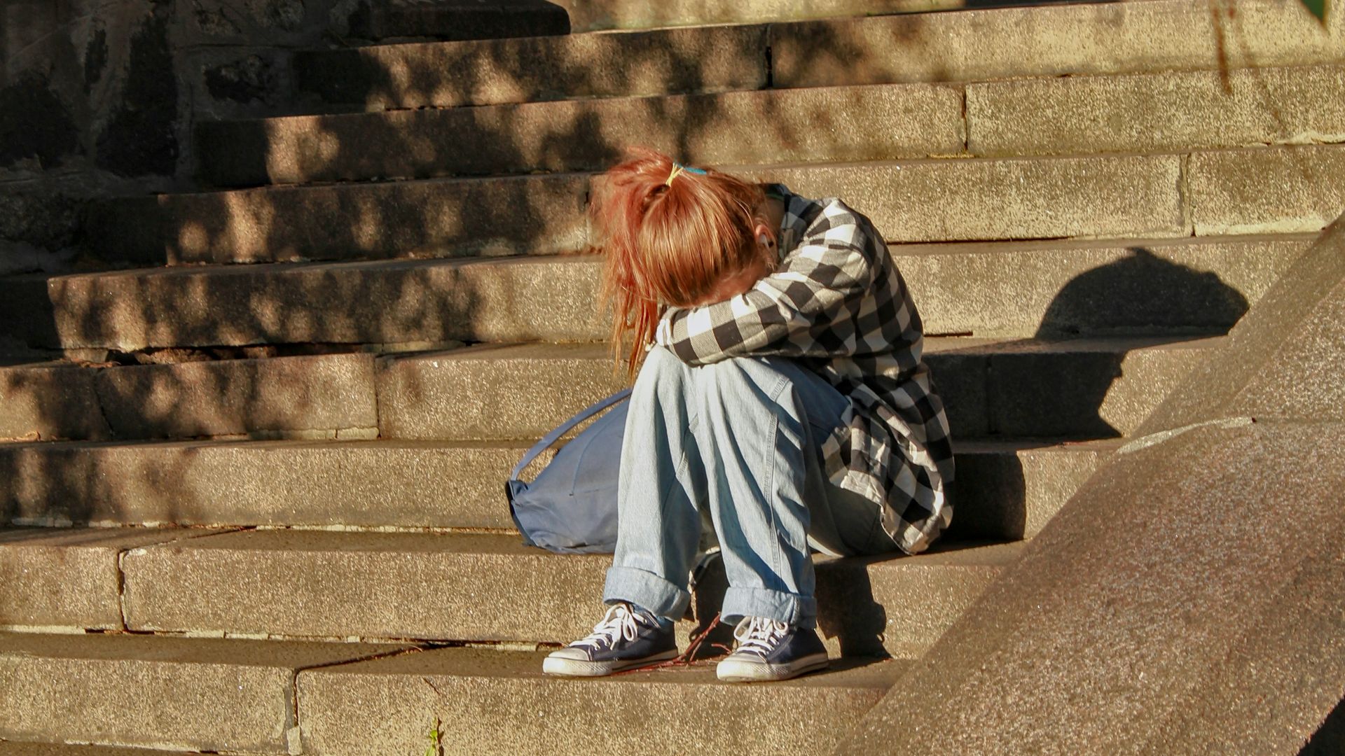 woman in black and white dress sitting on concrete stairs