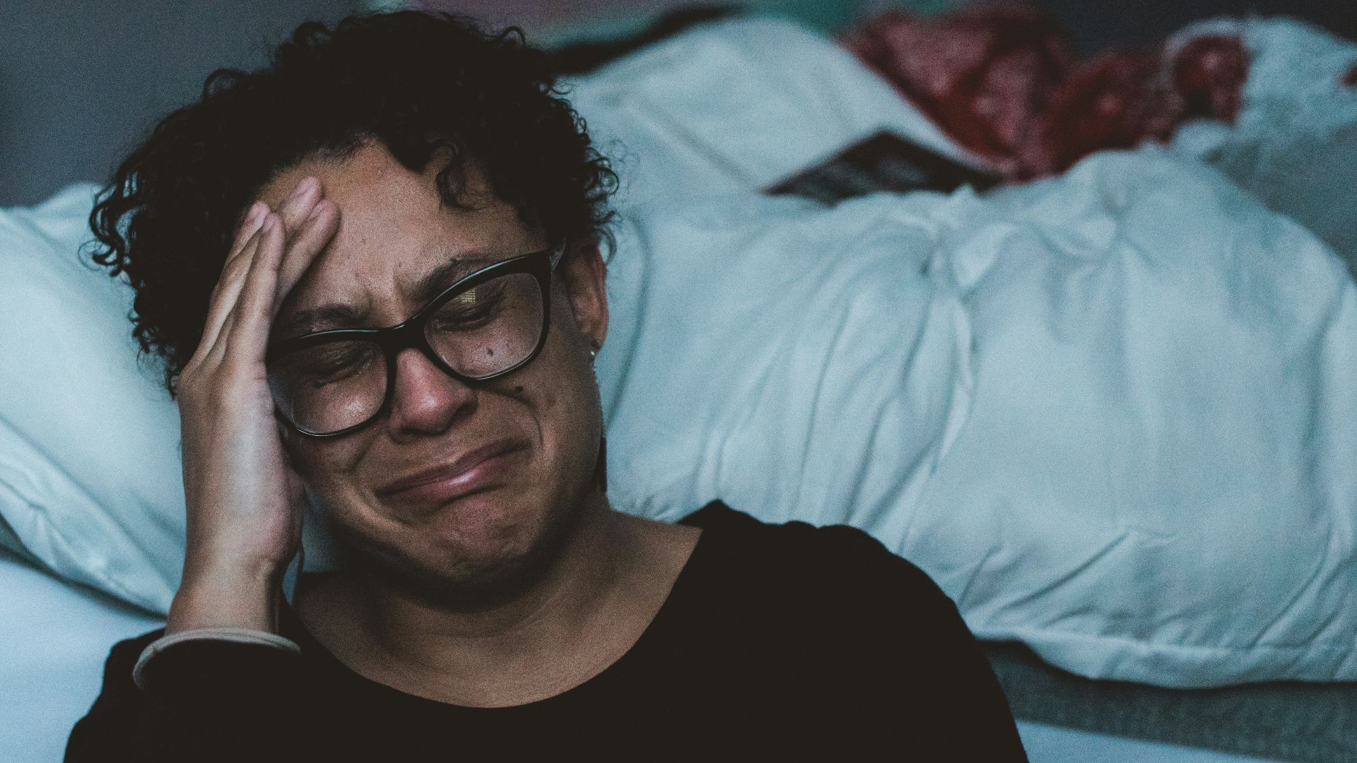 person crying beside bed