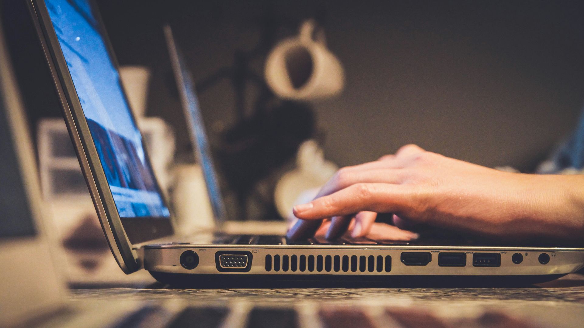 person using silver laptop computer on desk