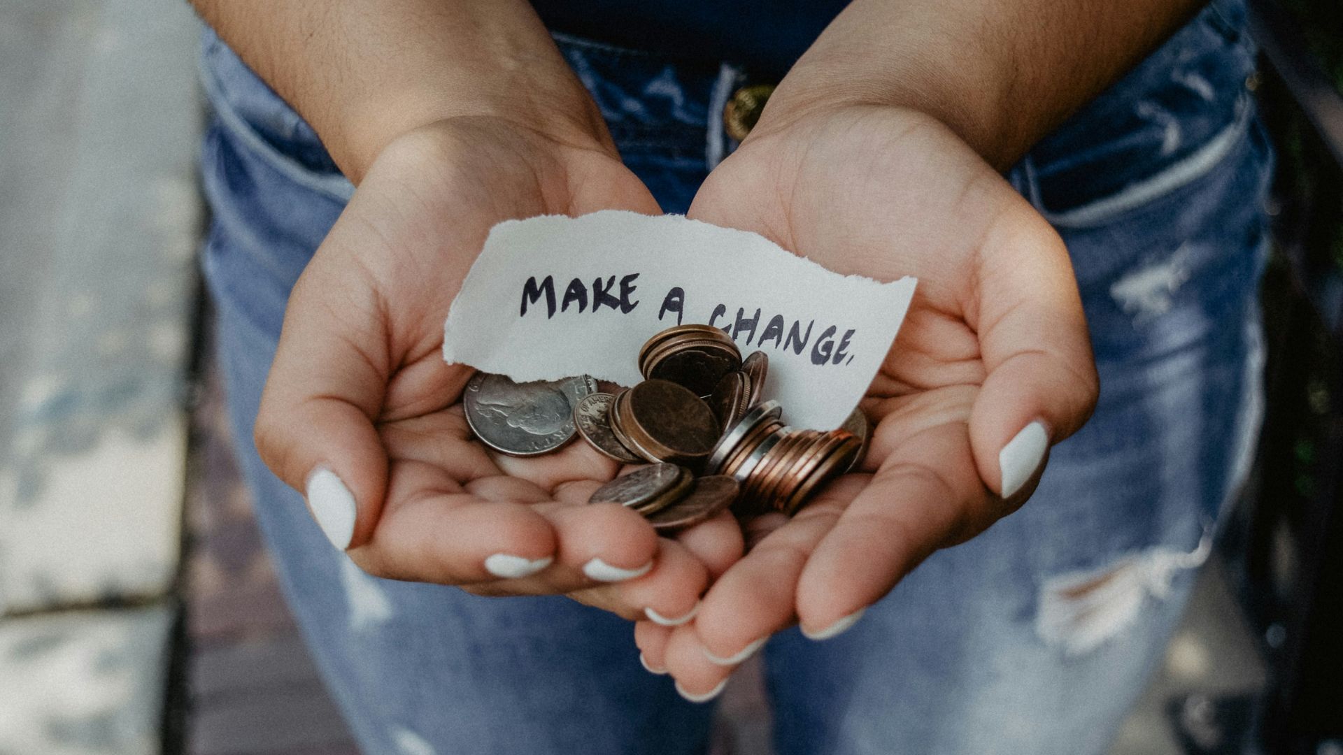 person showing both hands with make a change note and coins