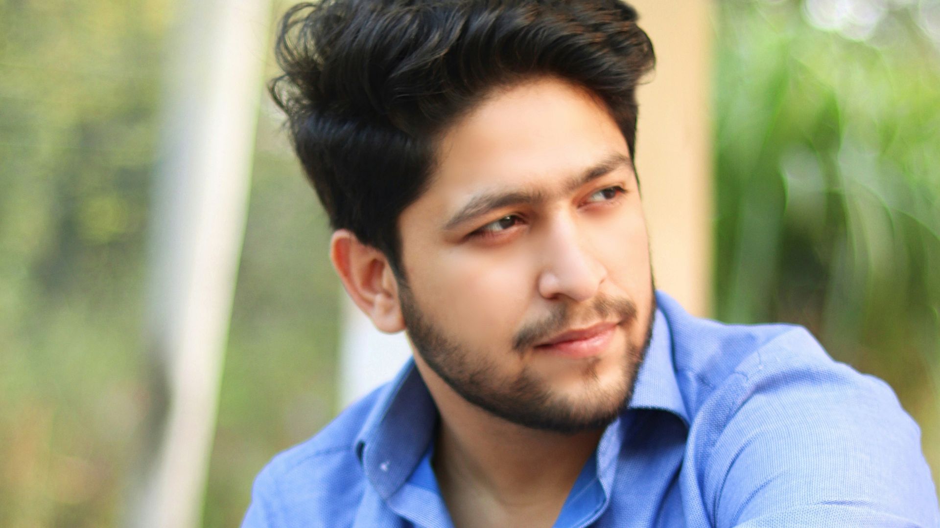 man in blue dress shirt and white pants sitting on concrete bench during daytime