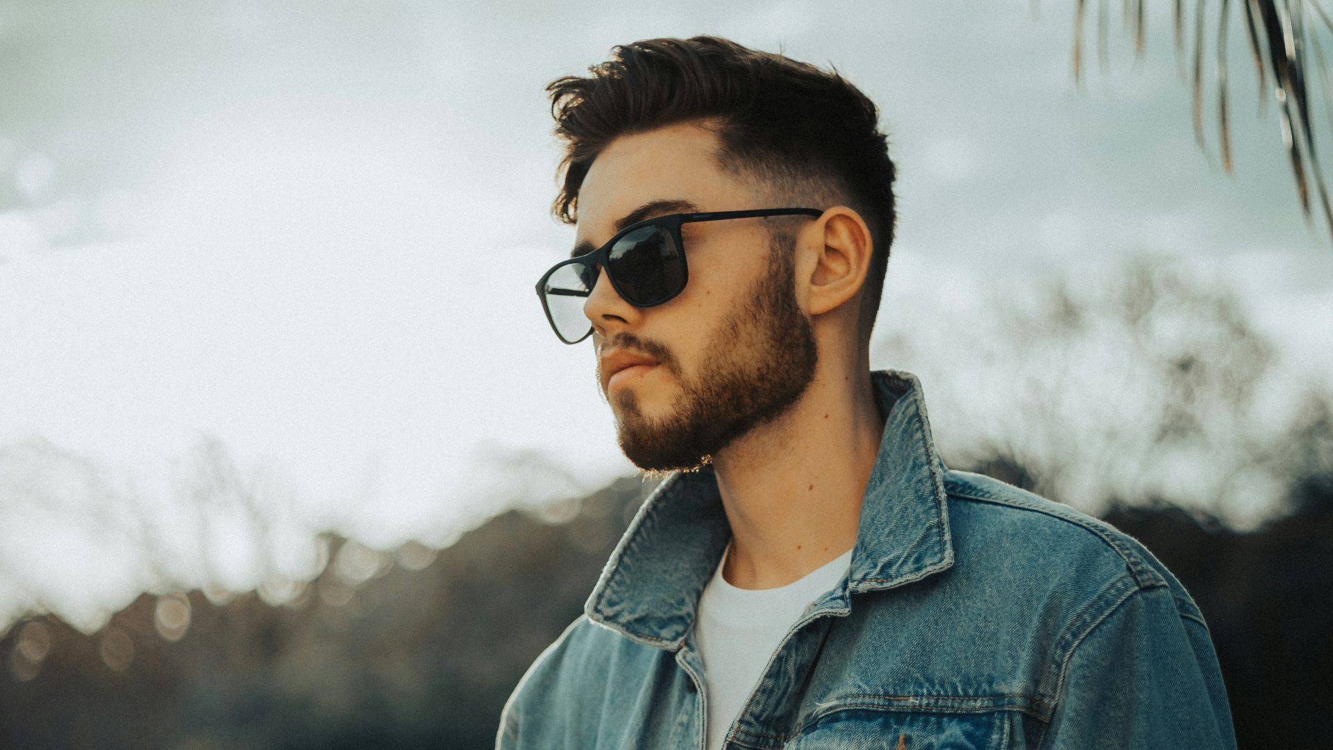 man in blue denim jacket wearing black sunglasses