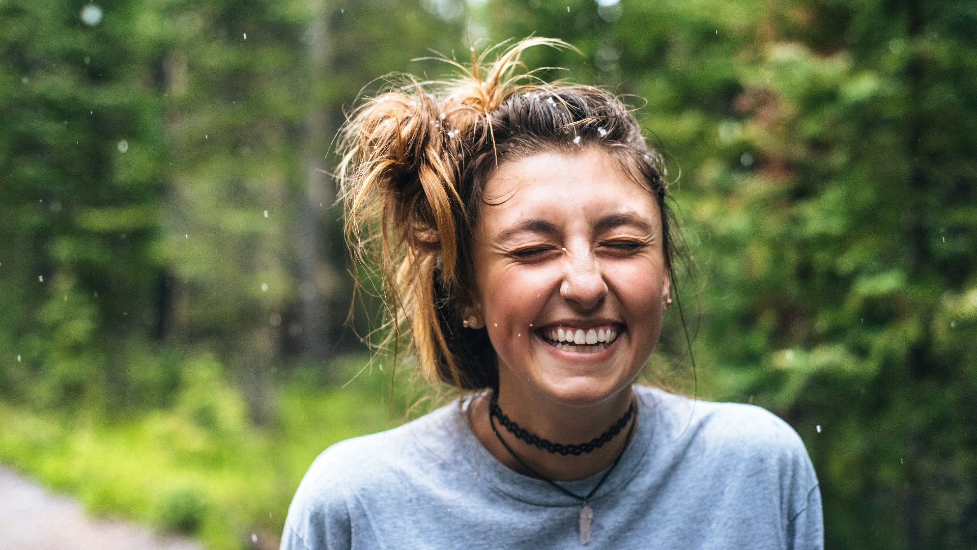 woman smiling near tree outdoor during daytime