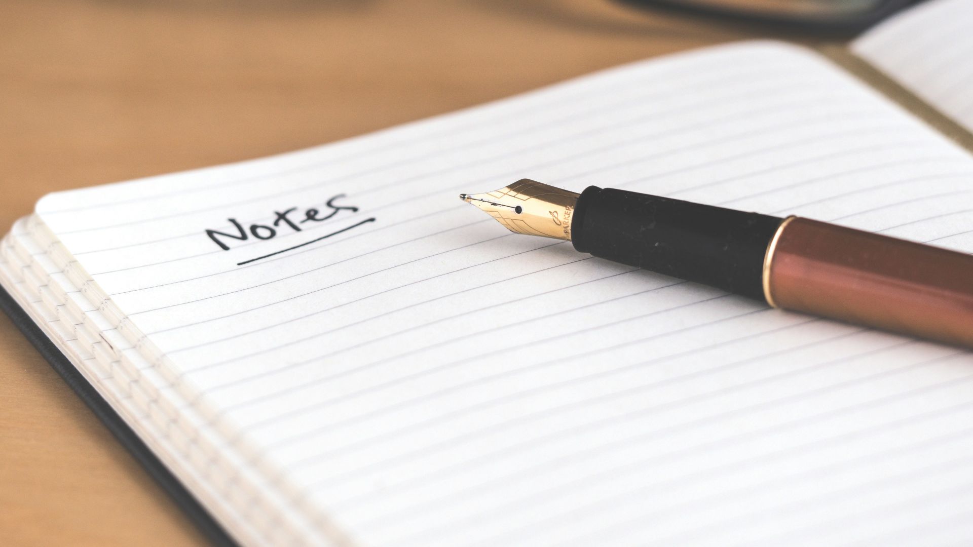 brown fountain pen on notebook