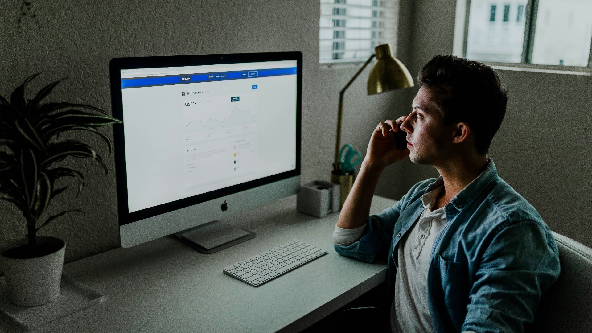 man in blue denim jacket facing turned on monitor