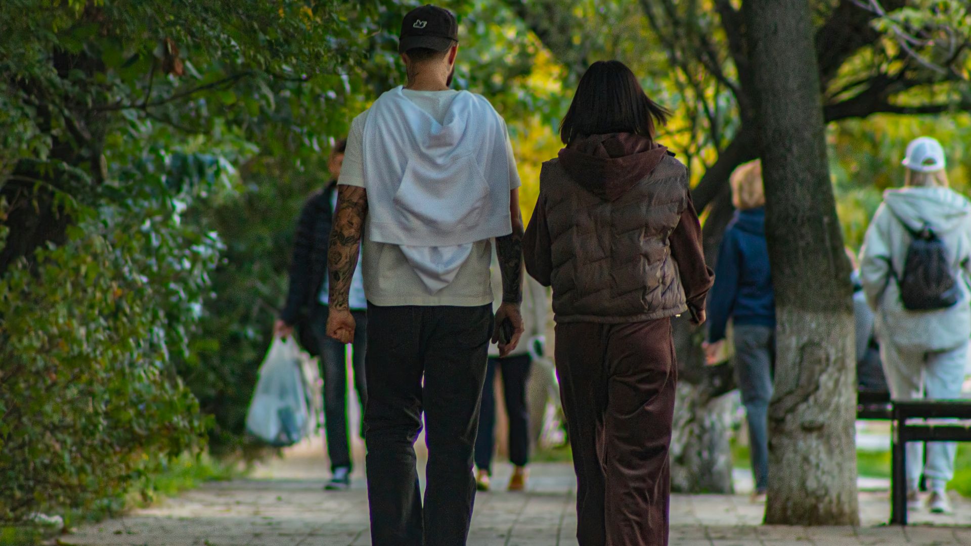 A group of people walking down a sidewalk
