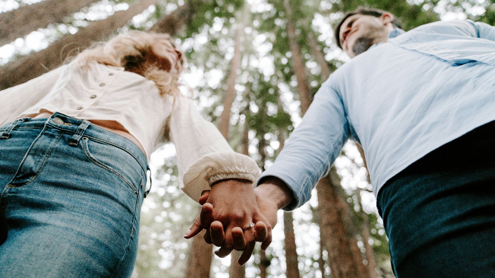 shalow focus photo of man and woman holding each others hands