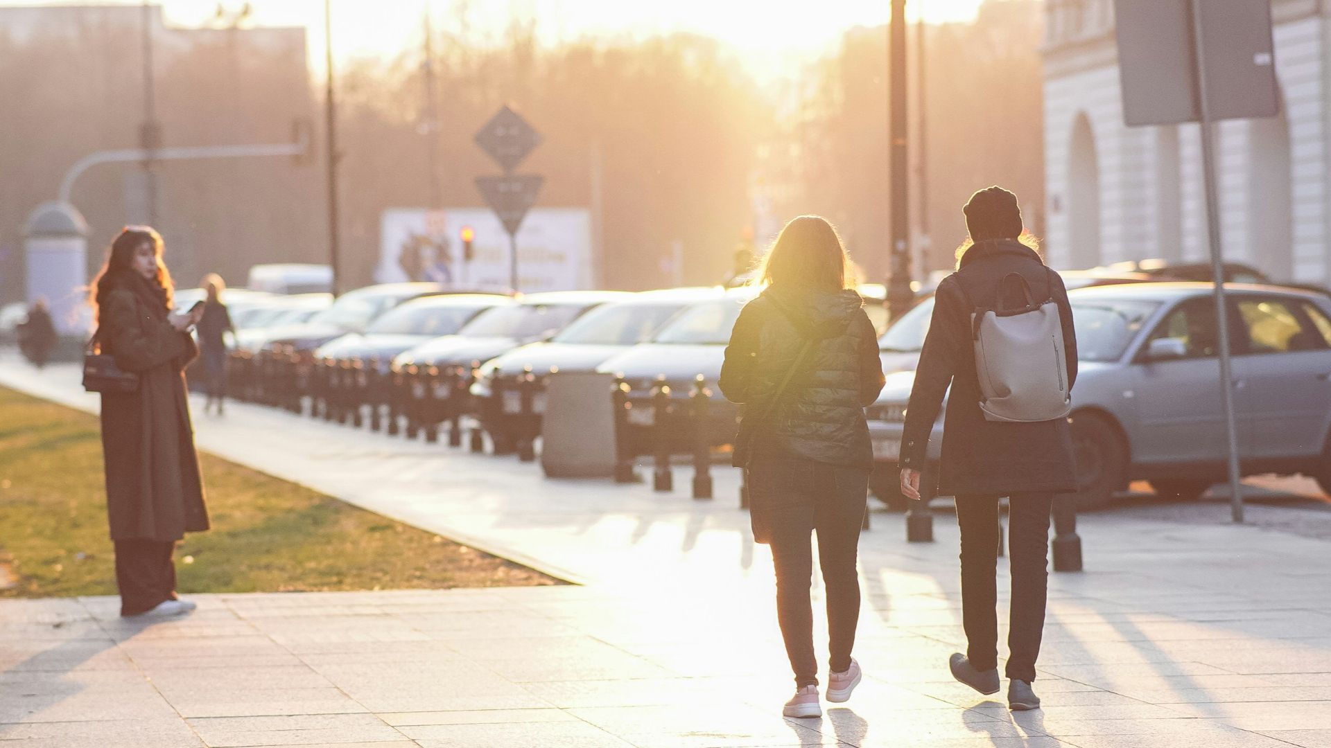 a group of people walking down a sidewalk