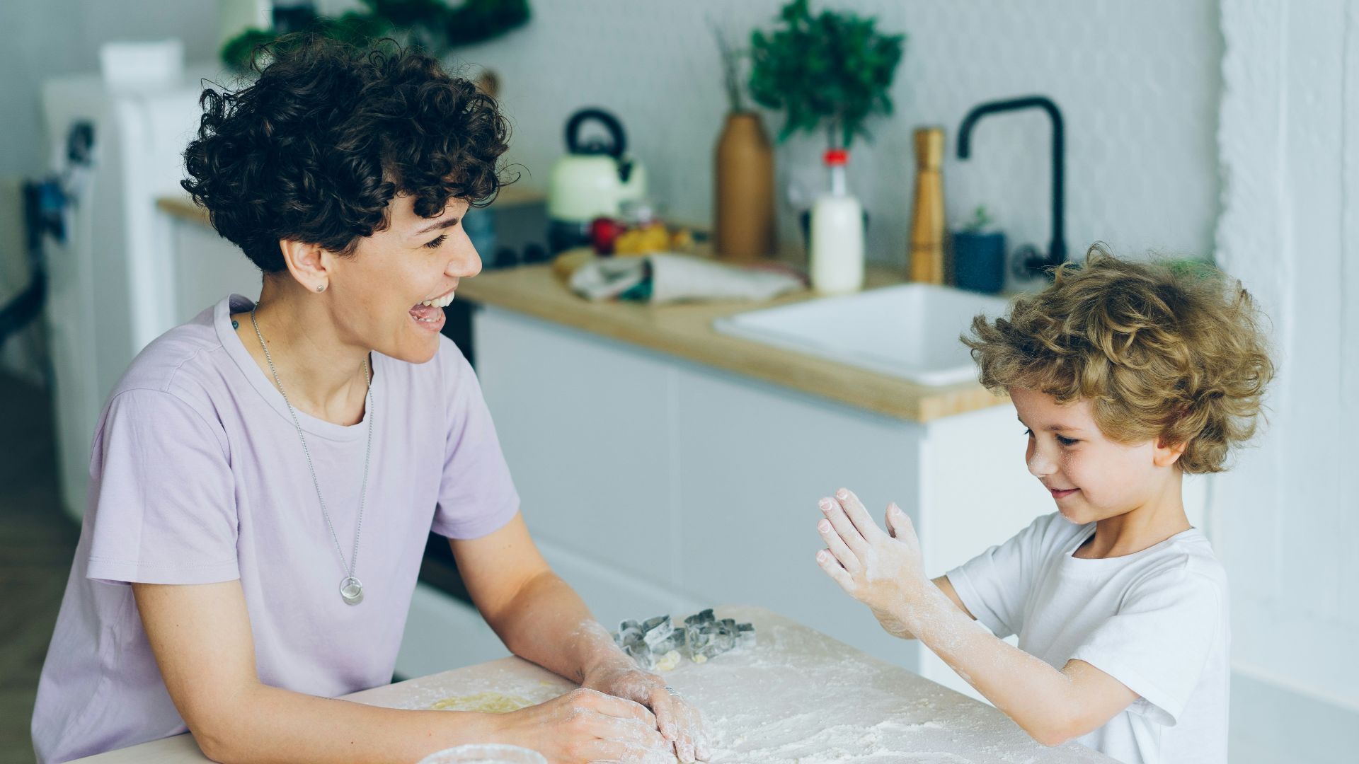 a woman and a child sitting at a kitchen table