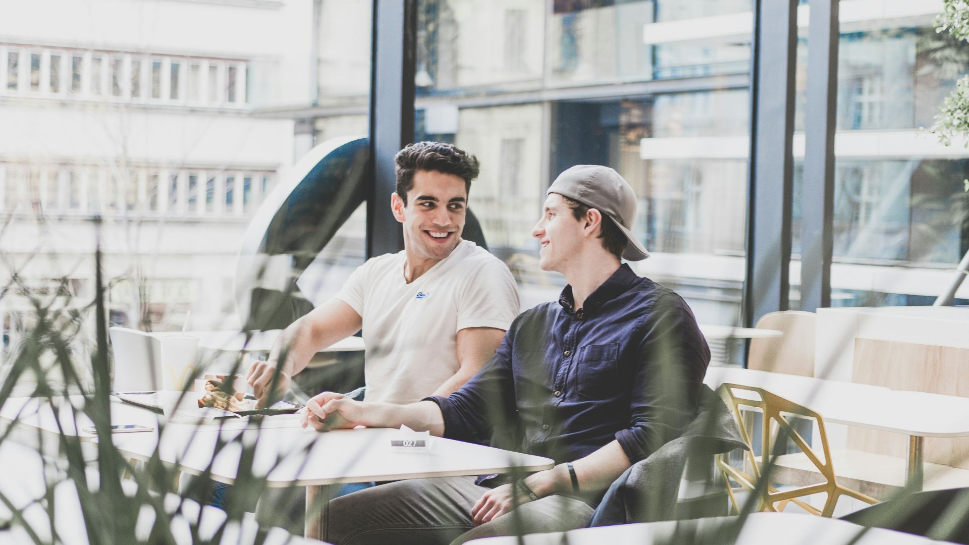two men sitting on chair in front of table