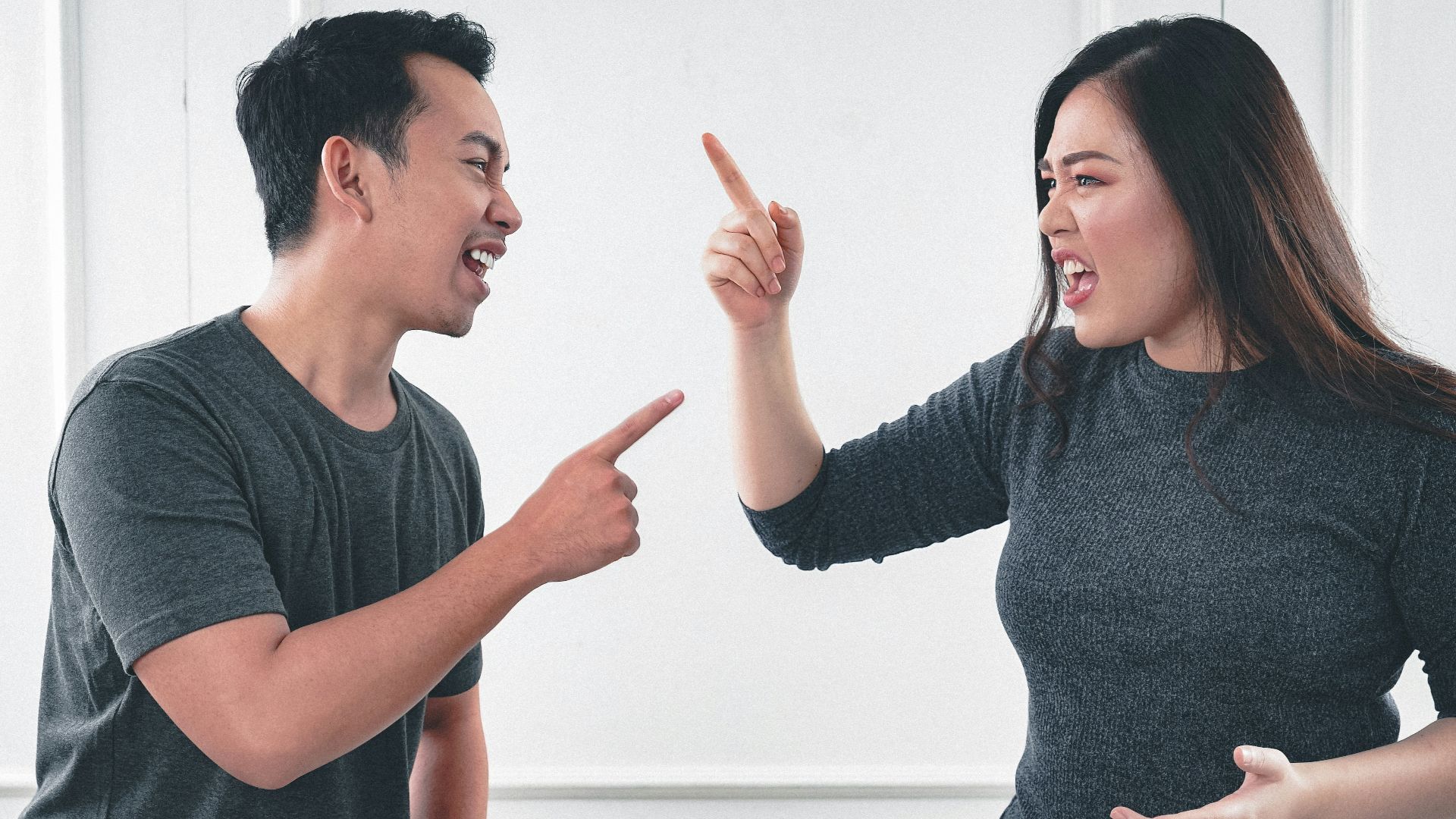 man in gray crew neck long sleeve shirt standing beside woman in black crew neck shirt