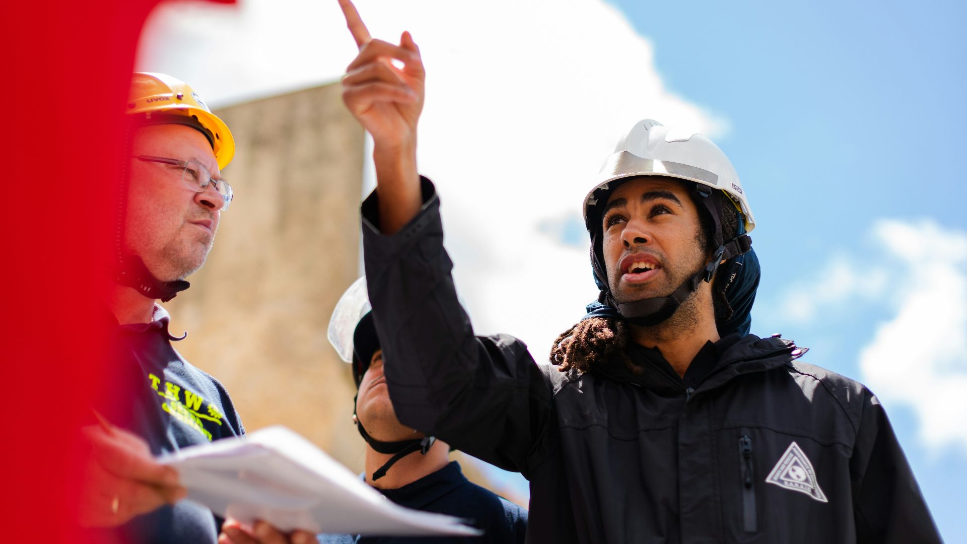 man in black jacket wearing yellow hard hat
