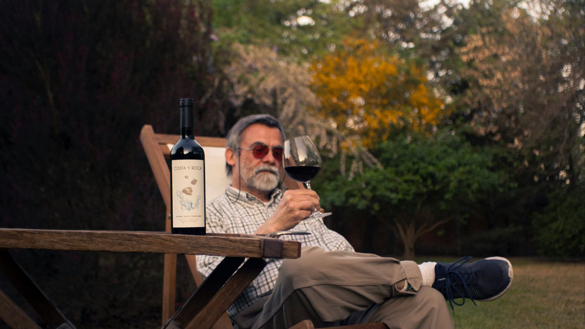 a man sitting in a chair holding a glass of wine