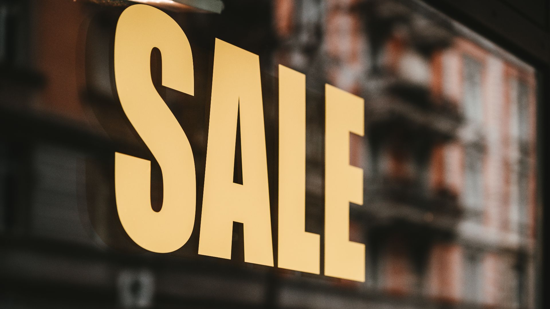 yellow sale text printed on glass window