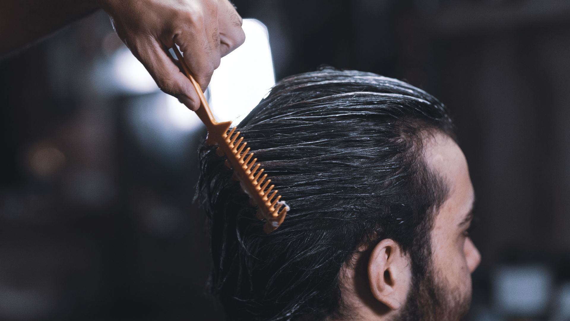 woman in white long sleeve shirt holding brown hair brush