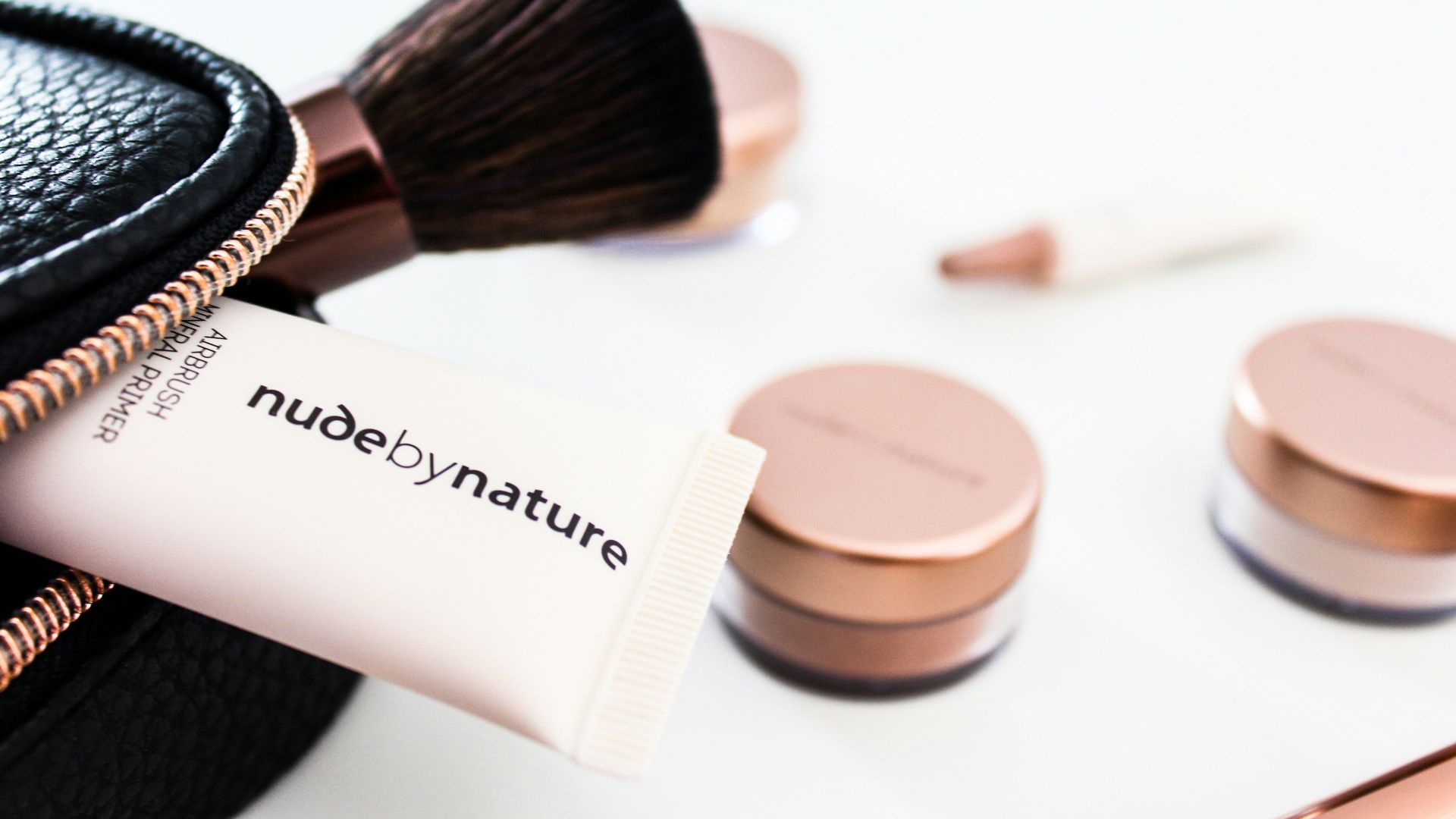 Nude by Nature soft-tube beside brown makeup brush