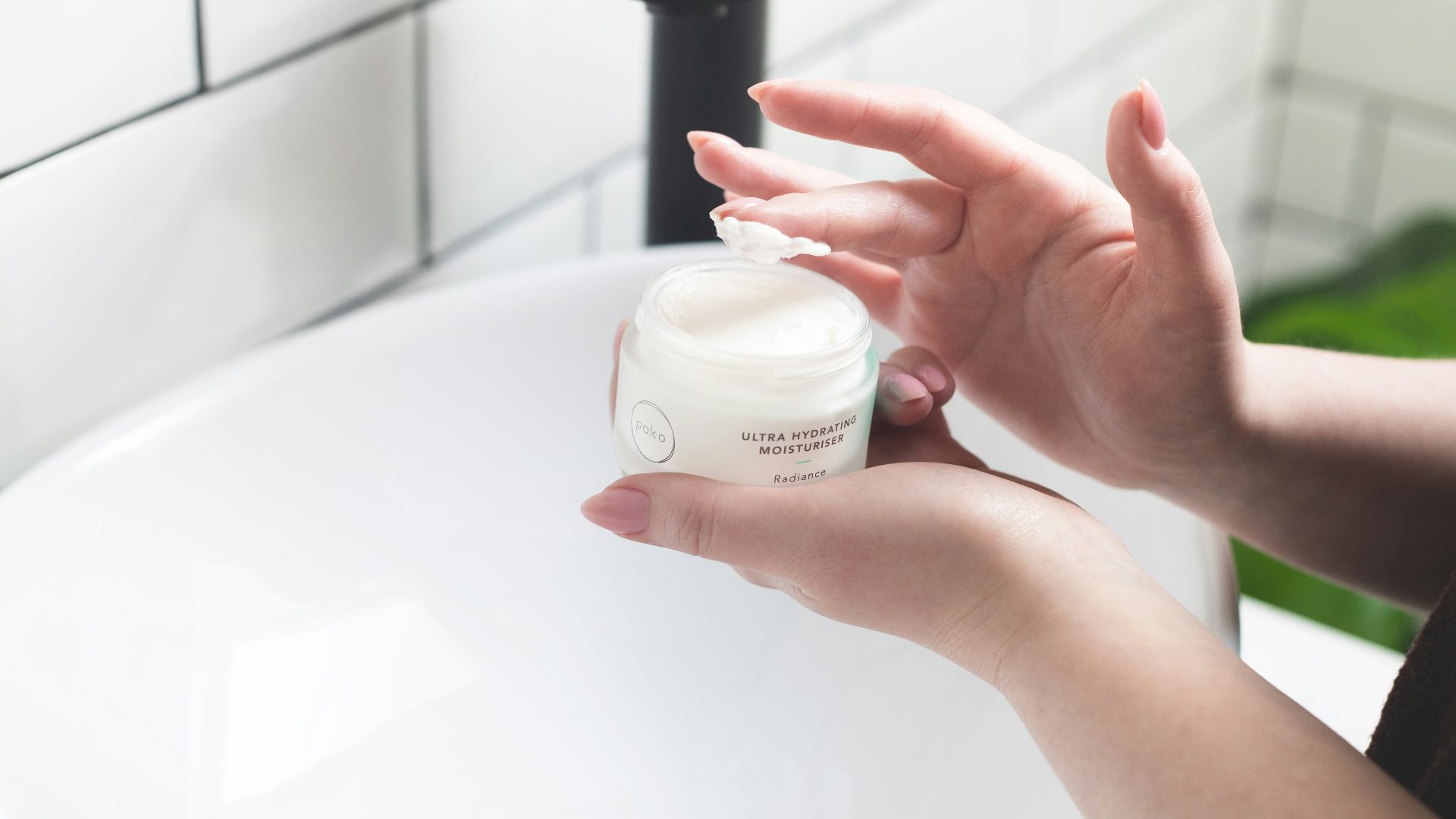 person holding white and black plastic bottle